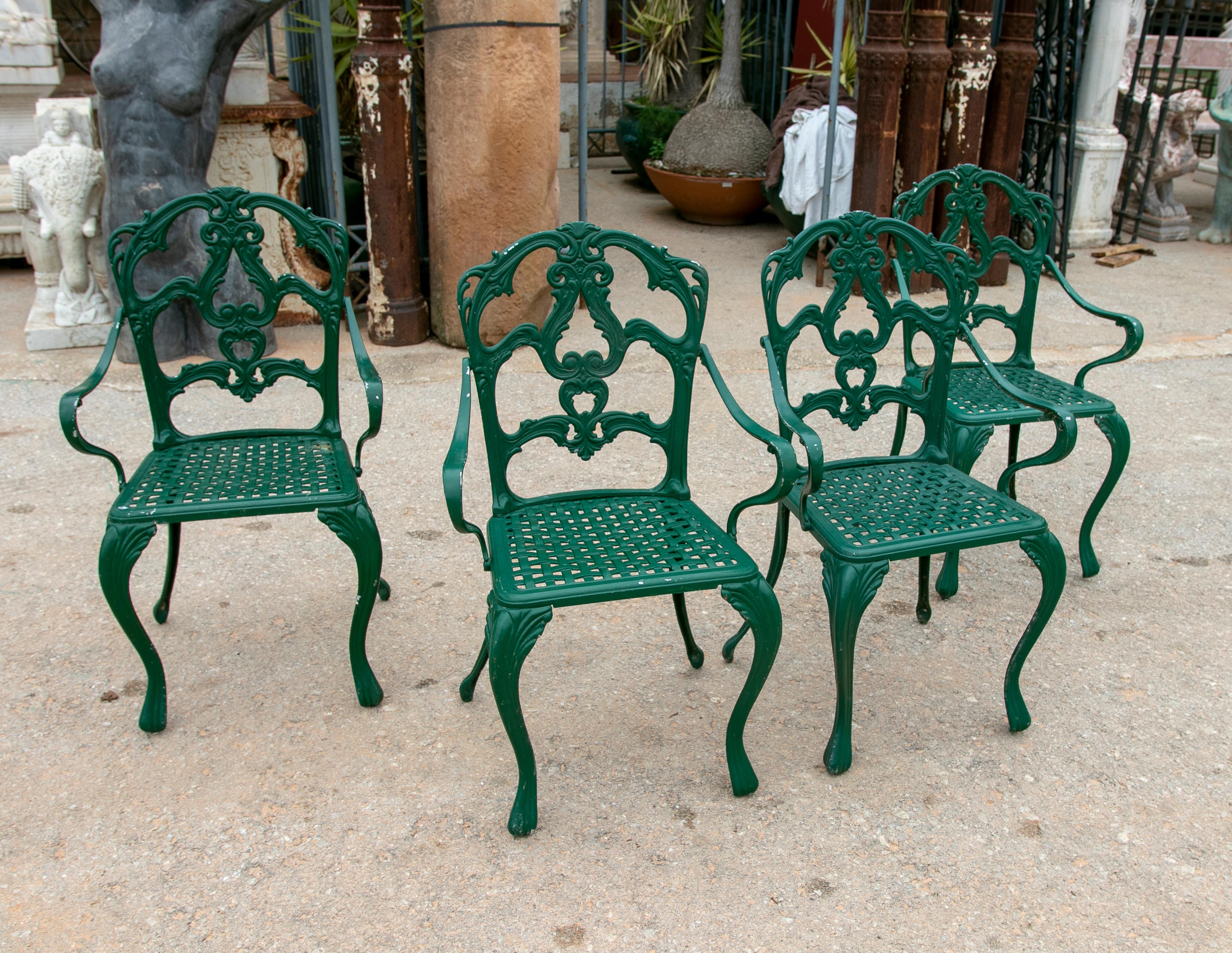 1980s set of four green-painted iron chairs.