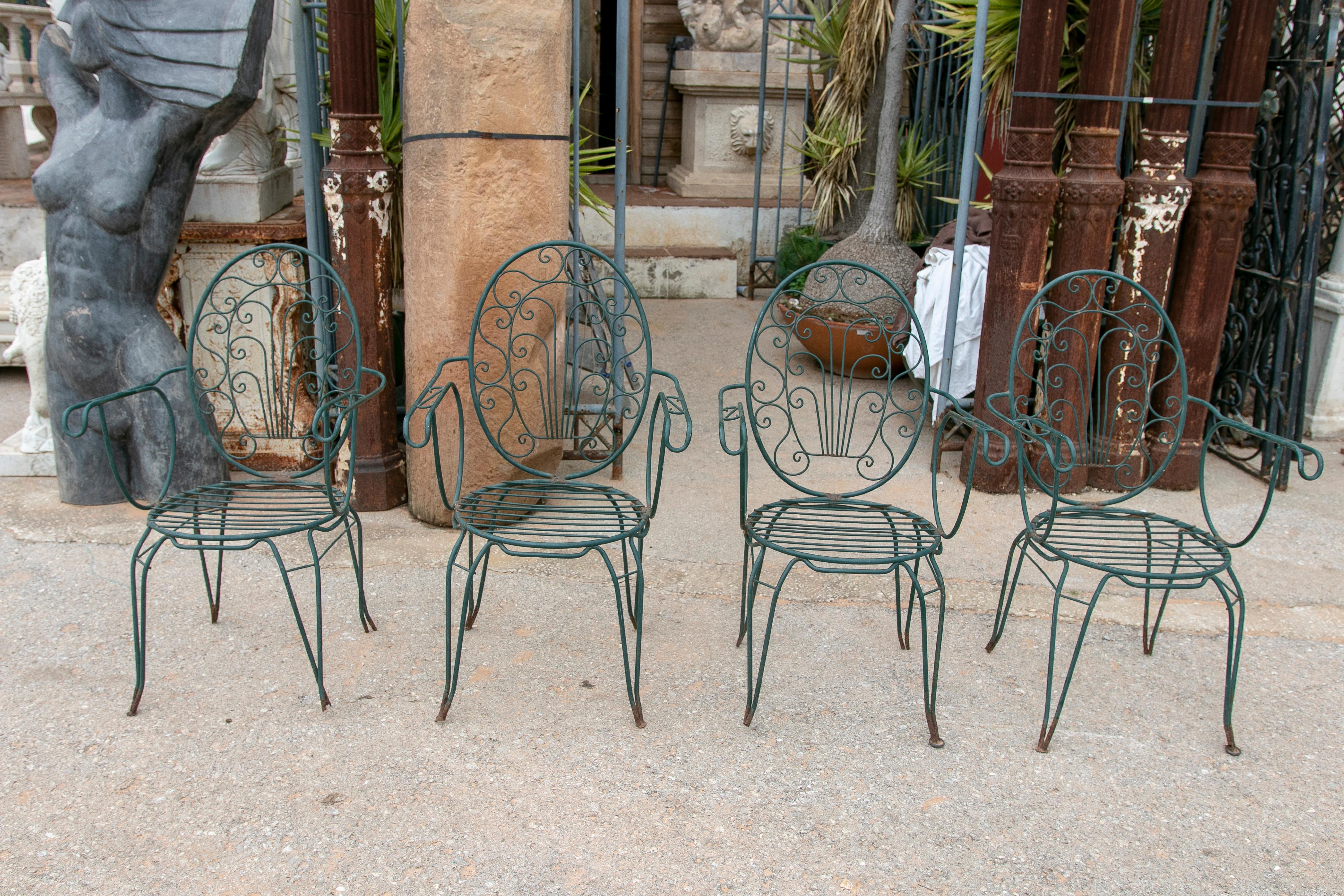Ensemble de quatre chaises en fer peintes en vert, datant des années 1980.