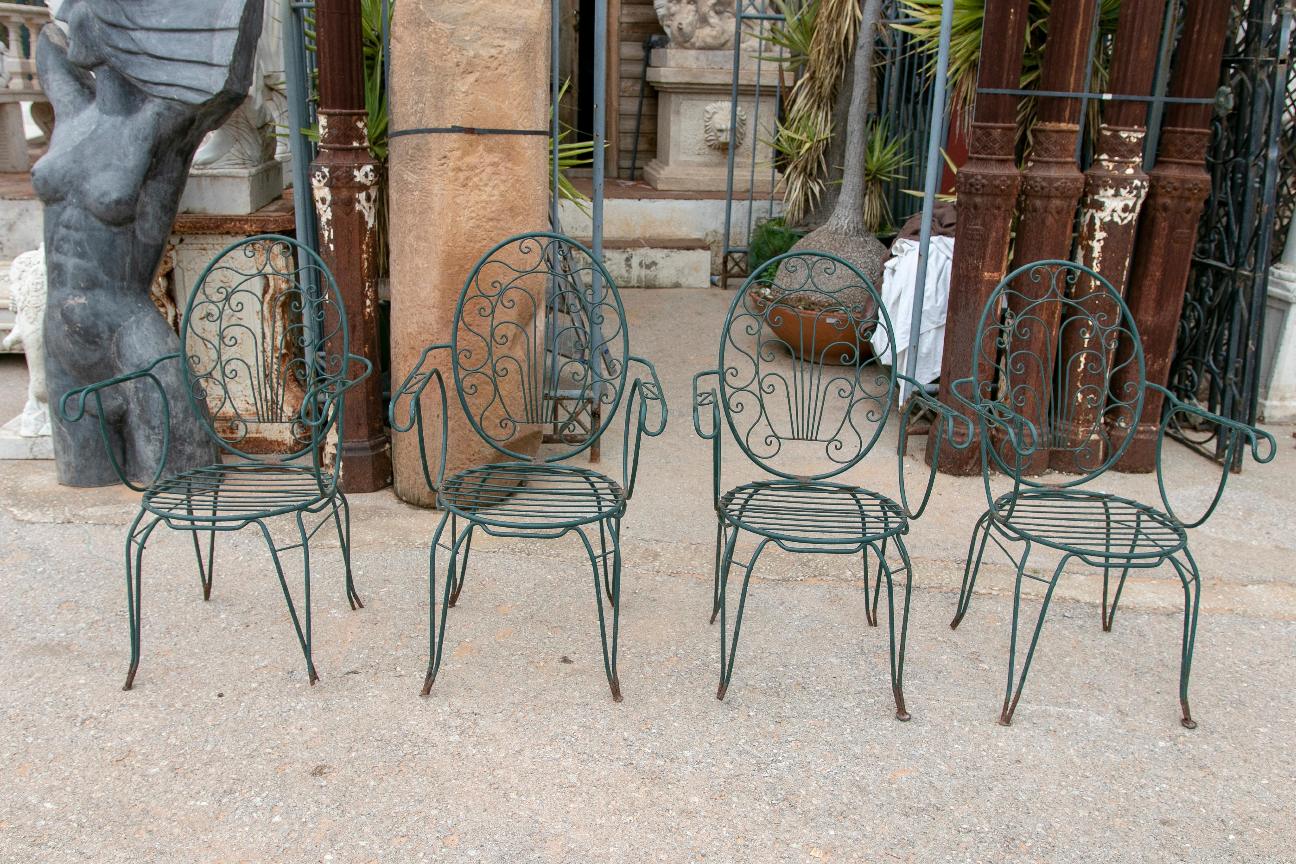 1980s set of four green-painted iron chairs.