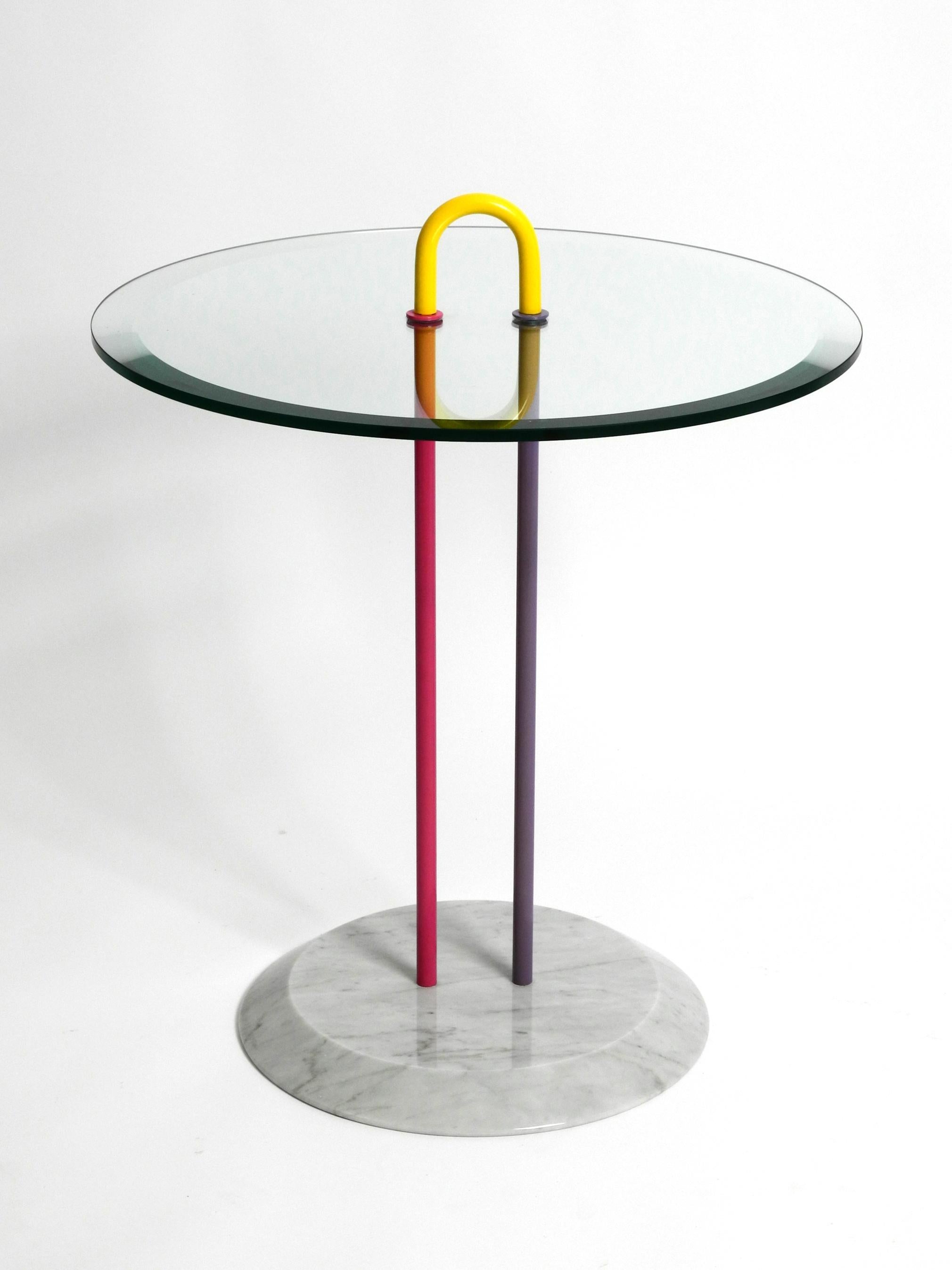 Beautiful, very heavy round side table made of glass and marble. 
Manufactured in the 1980s in Memphis design. Made in Italy.
Vico Magistretti for Cattelan Italia. Very classy minimalist design. Very rare in this colorful version.
Base is made of