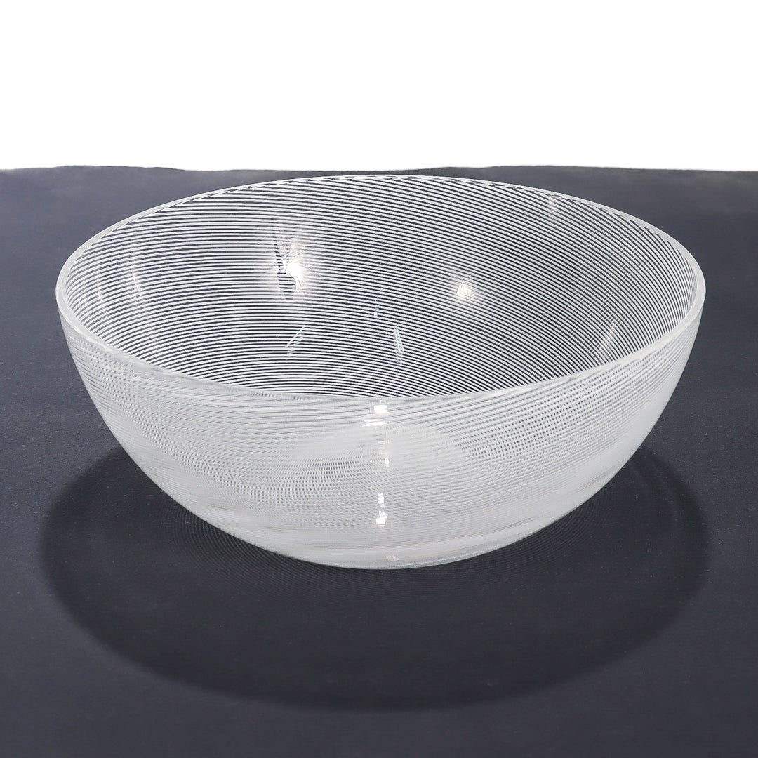 A fine Murano glass bowl.

By Venini.

In colorless glass with fused thread of opaque white lattimo. 

Likely inspired by one of Carlo Scarpa's early designs.

Signed with an etched signature to the base 'Venini 87'.

Simply a wonderful Venini