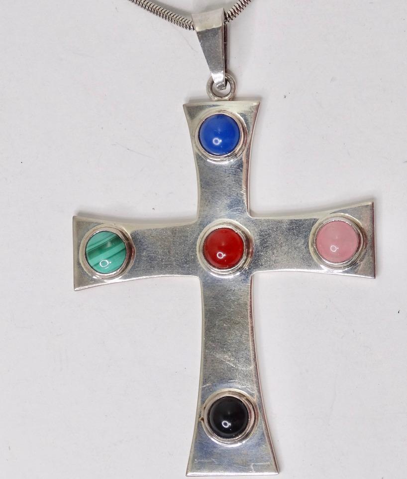 This 1980s silver plated cross pendent is going to become your next go to pendent necklace! A large silver cross pendent features a beautiful arrangement of pink, red, blue, and black stones on a silver tone chain. Style this layered with a Vivienne