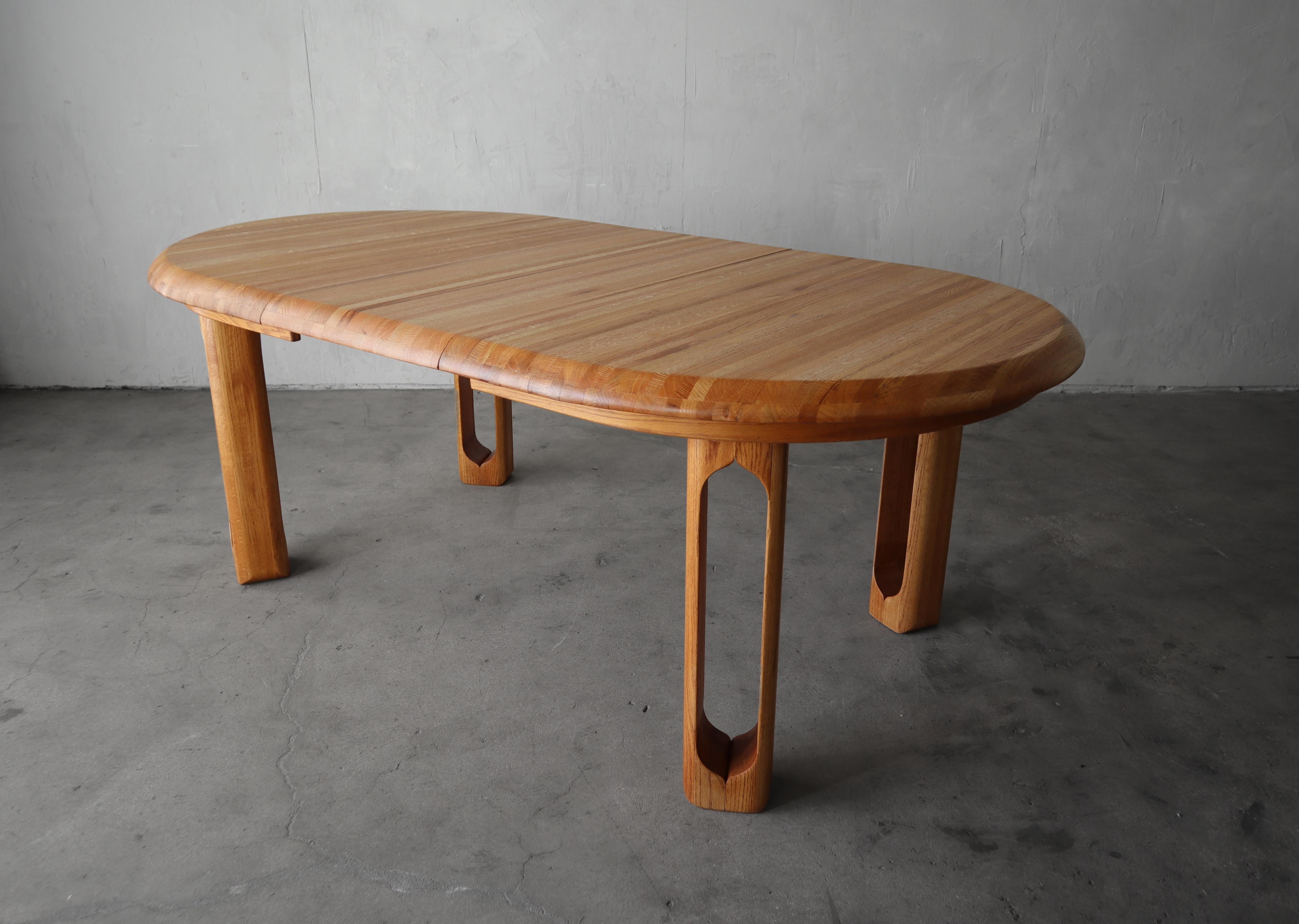 Esta preciosa mesa de comedor extensible ovalada de roble de los años 80 es una obra maestra hecha a mano.  Me encanta el detalle tallado de las patas y la variación de grano y color en todas las tablas de madera utilizadas en la tapa de madera