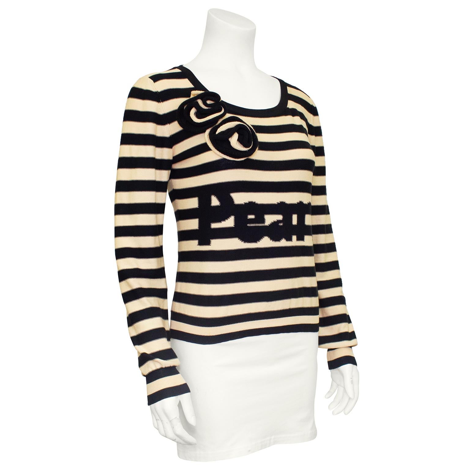 Sonia Rykiel sweater from the 1980s. Contrasting horizontal beige and black stripes with two black and beige rosettes above right bust and 'Pearl' in black block letters across the chest. Black trim scoop neckline with ribbed cuffs and waistband.