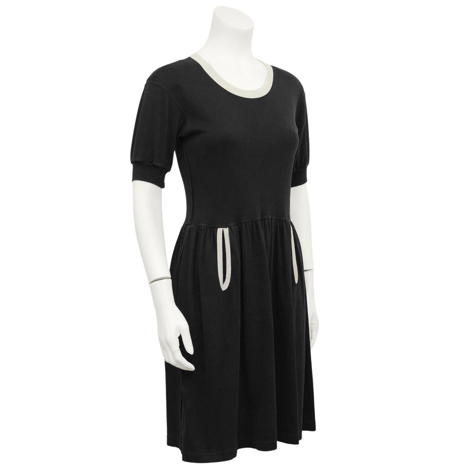 1980s Sonia Rykiel comfy cotton jersey knit day dress. Fit and flare shape, with a crew neckline and short bishop sleeves. Black with contrasting white ribbed trim at neckline and slit pockets. Pockets are a slight teardrop shape. Excellent vintage