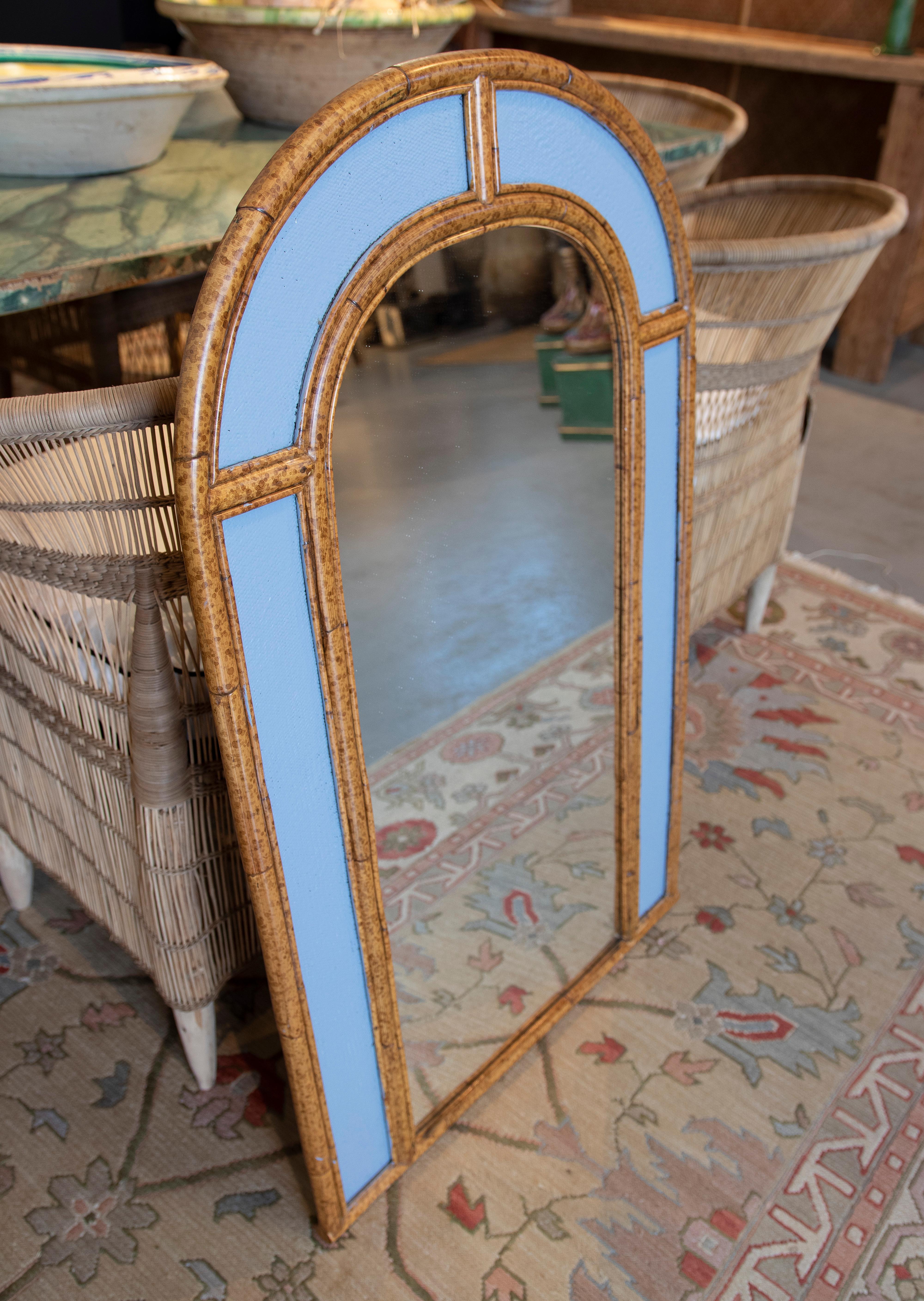 Vintage 1980s Spanish arched bamboo and cane wall mirror with indigo panels.

 