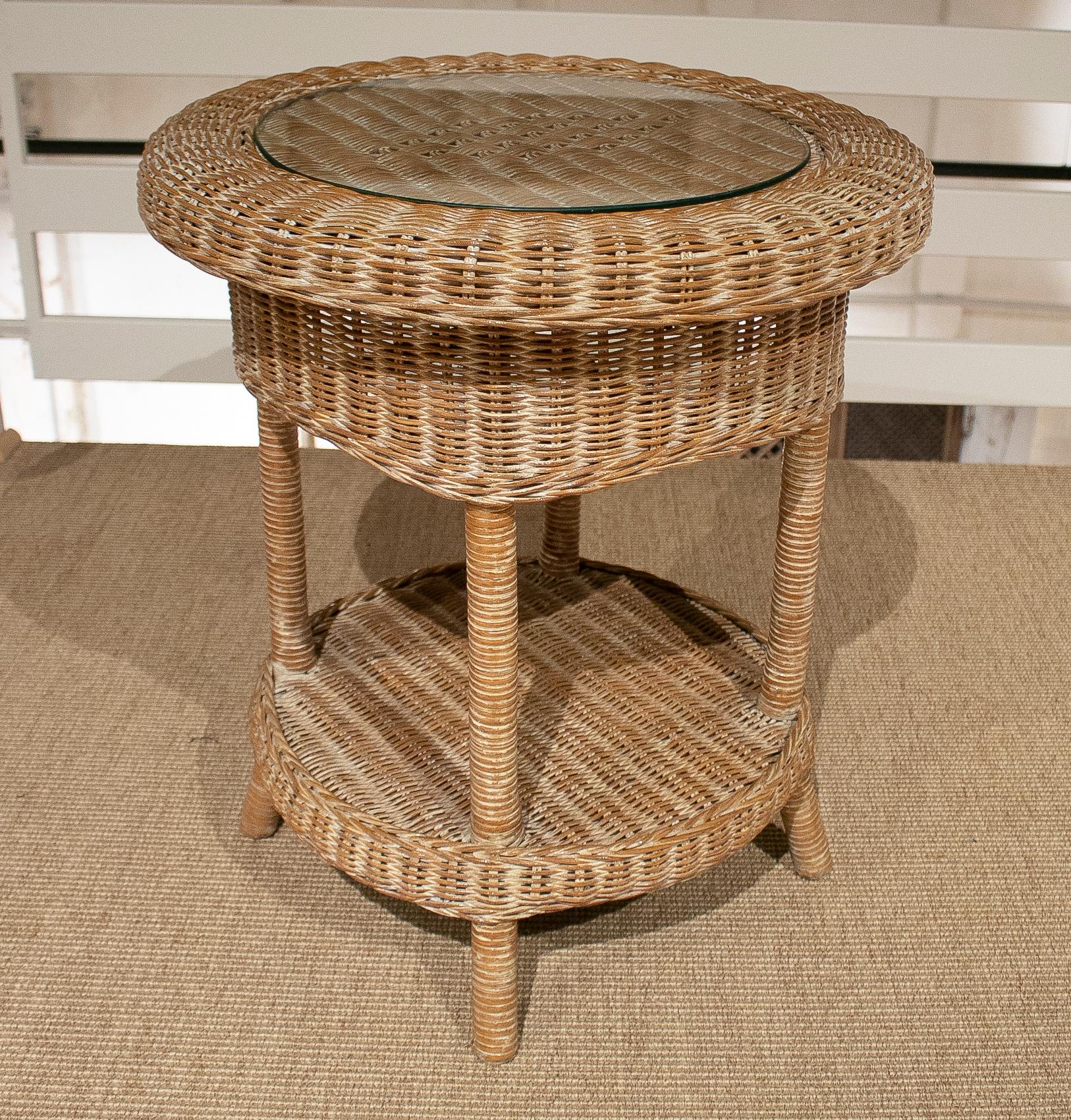 Vintage 1980s Spanish round hand woven wicker side table with glass top.