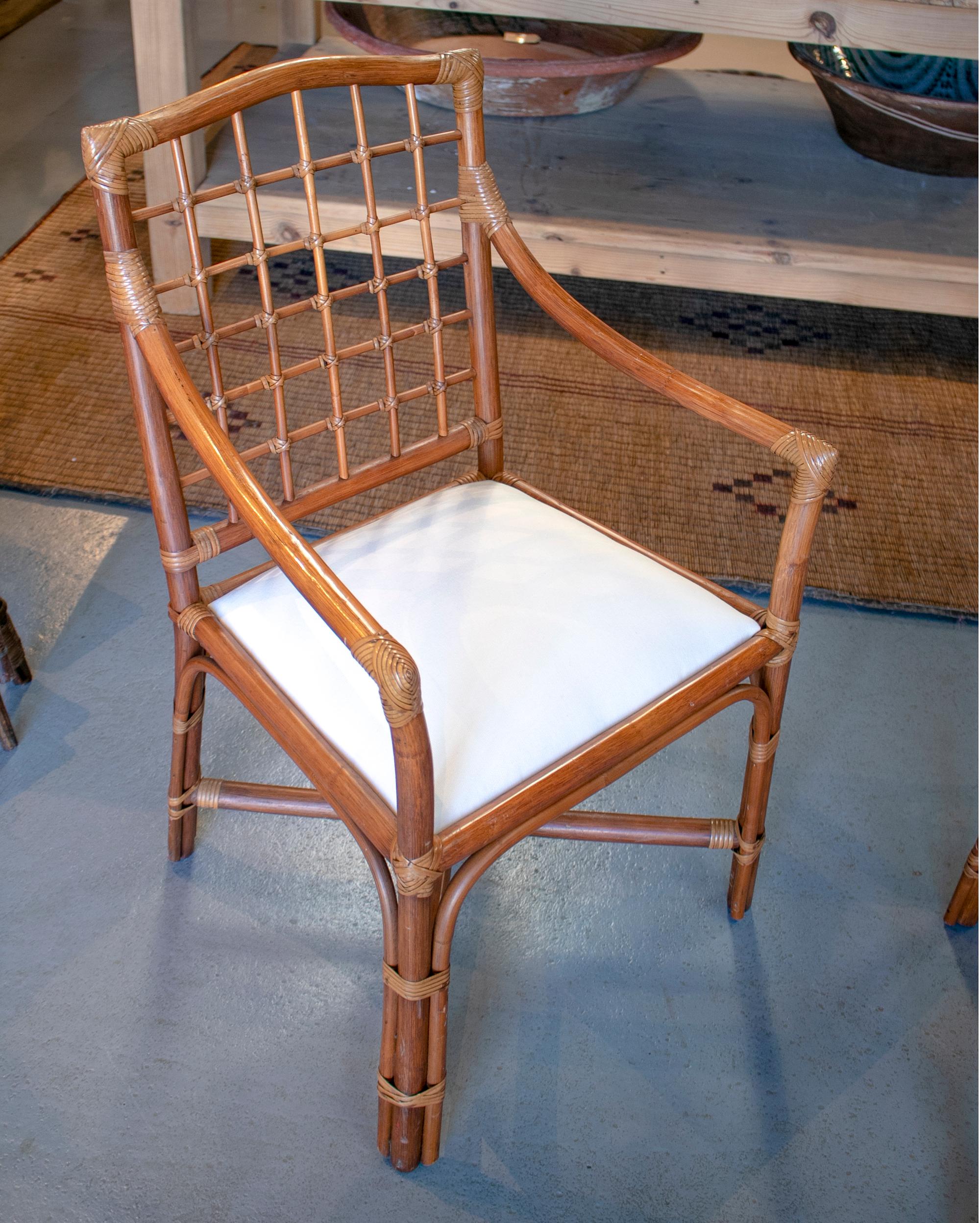 1980s Spanish set of four bamboo chairs with white upholstered seat cushions.