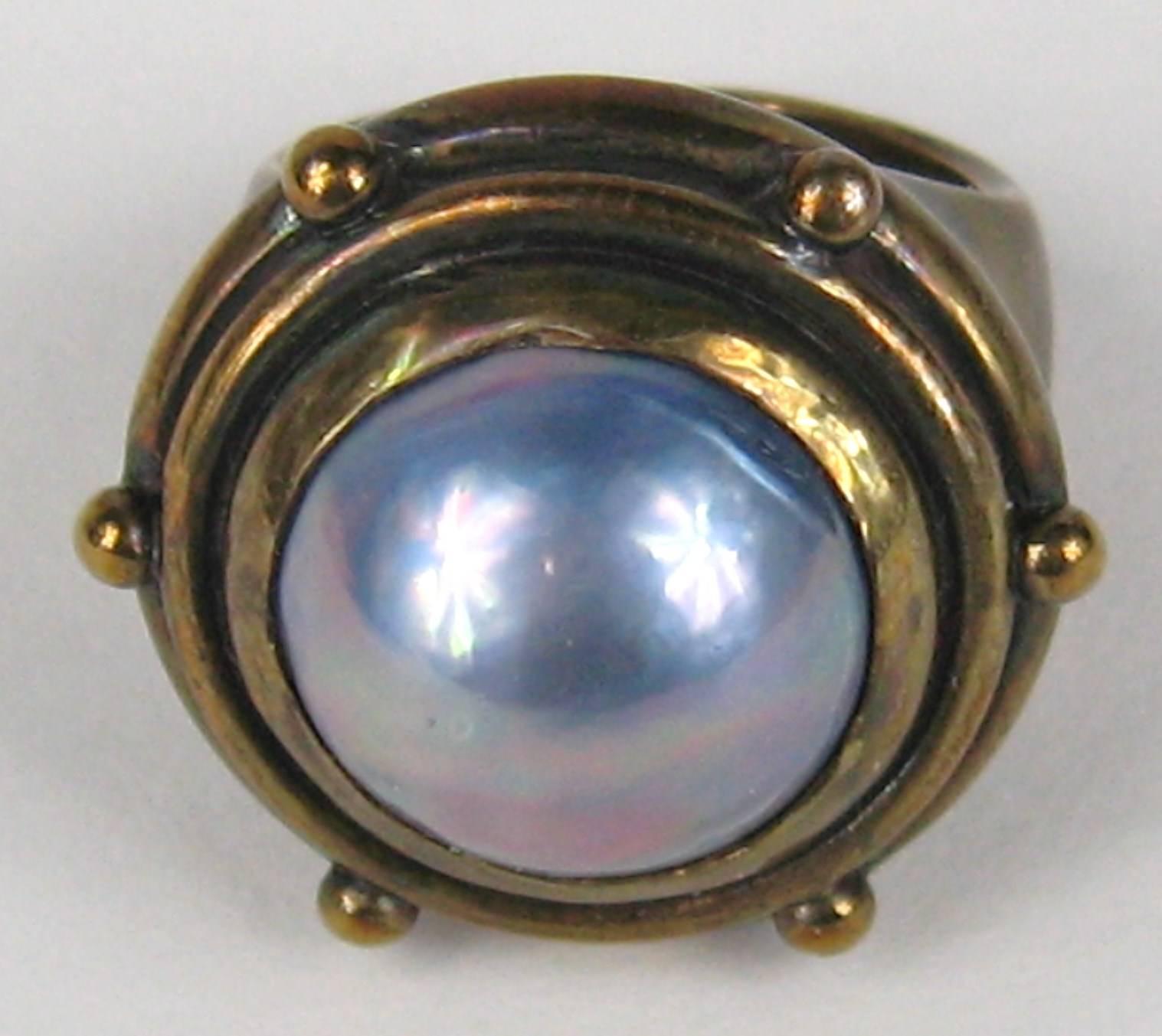 Large center Pearl on the Dweck Ring.  Size 6-3/4 in Top of ring is .86 in in diameter. Color on the pearl closer to purple. 
This is out of a massive collection of Hopi, Zuni, Navajo, Southwestern, sterling silver, costume jewelry and fine jewelry