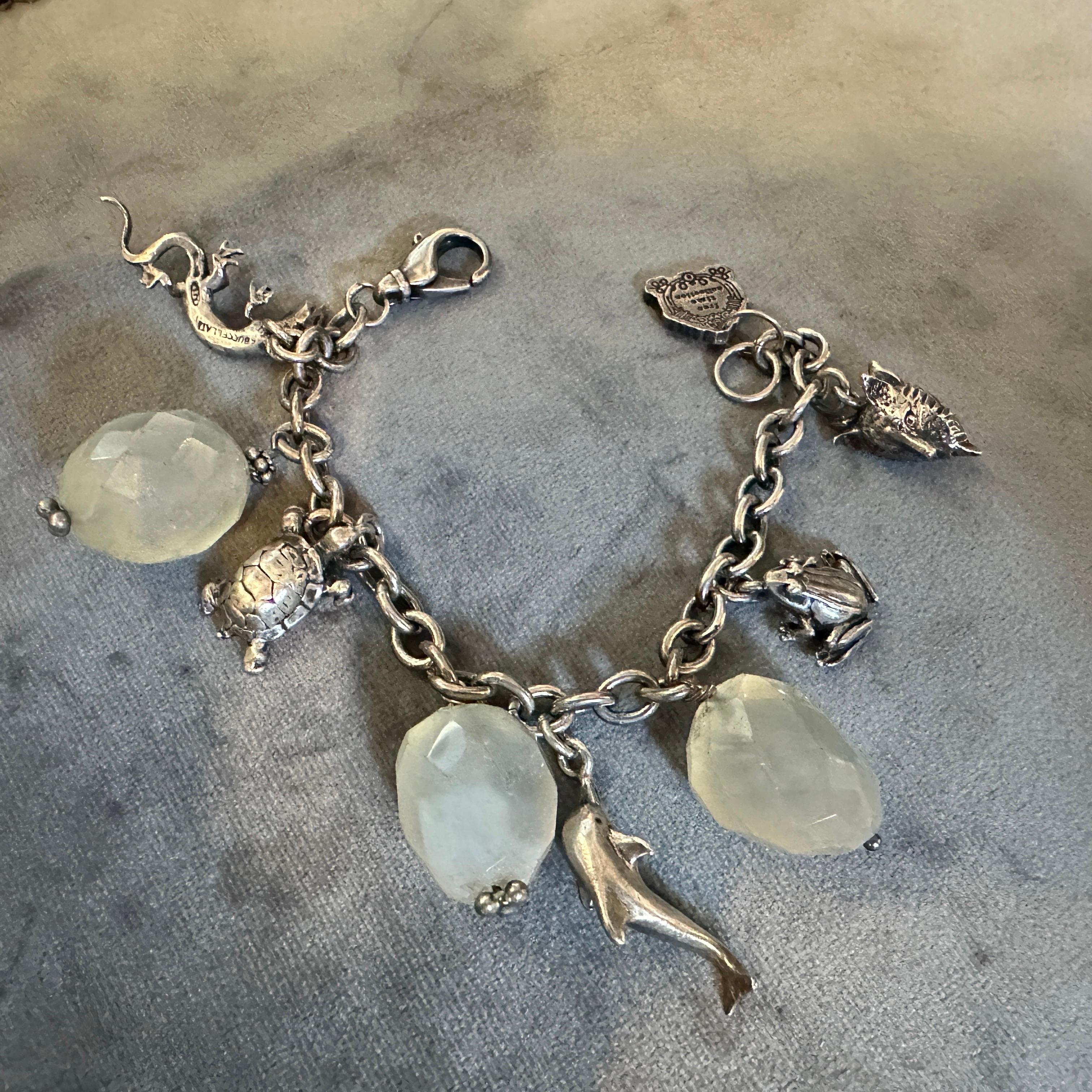 Questa creazione stravagante ed elegante del leggendario gioielliere italiano Mario Buccellati è un braccialetto di charme degli anni '80 realizzato in argento sterling e ornato da una deliziosa serie di ciondoli a tema animale. Le figure finemente