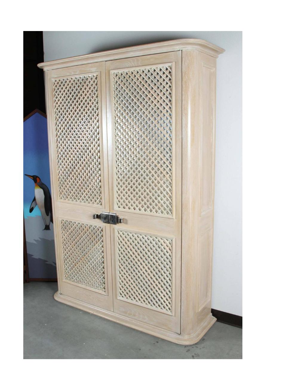 Lattice front armoire by Steve Chase. The armoire was custom designed for an Indian Wells estate completely designed by Mr. Chase.
The lattice front panels are backed with mirror and have nickel scroll pulls. The interior has several adjustable