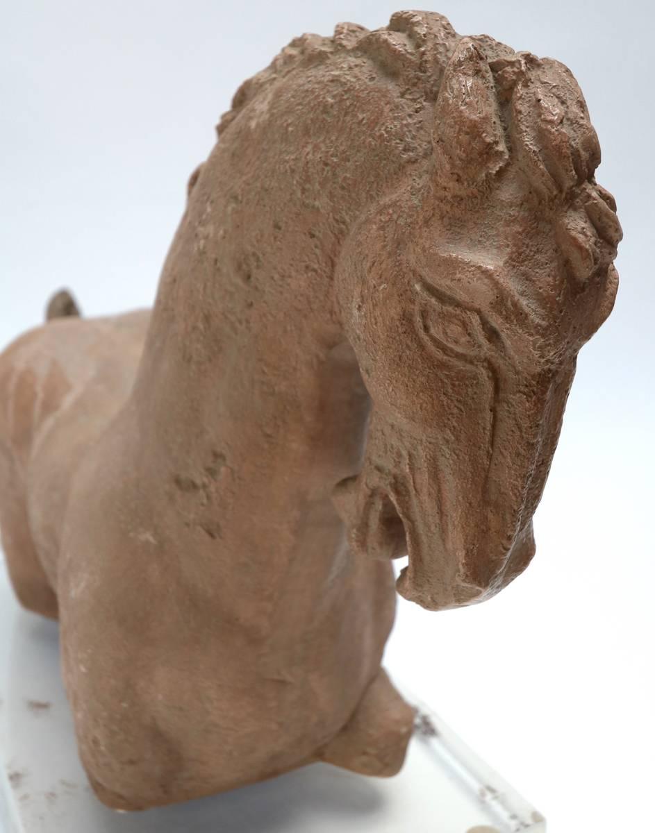 Tan stone horse sculpture on clear acrylic base, 1980s.
