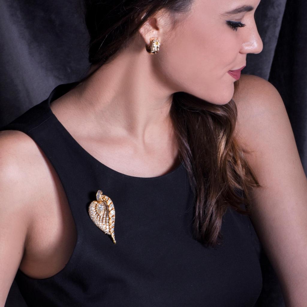 This breathtaking vintage lapel brooch  pin is crafted in solid 18K yellow gold set with high quality diamonds. Designed to simulate a stylized botanically inspired leaf profile, with delicate veins sparkling with graduated extra white diamonds.