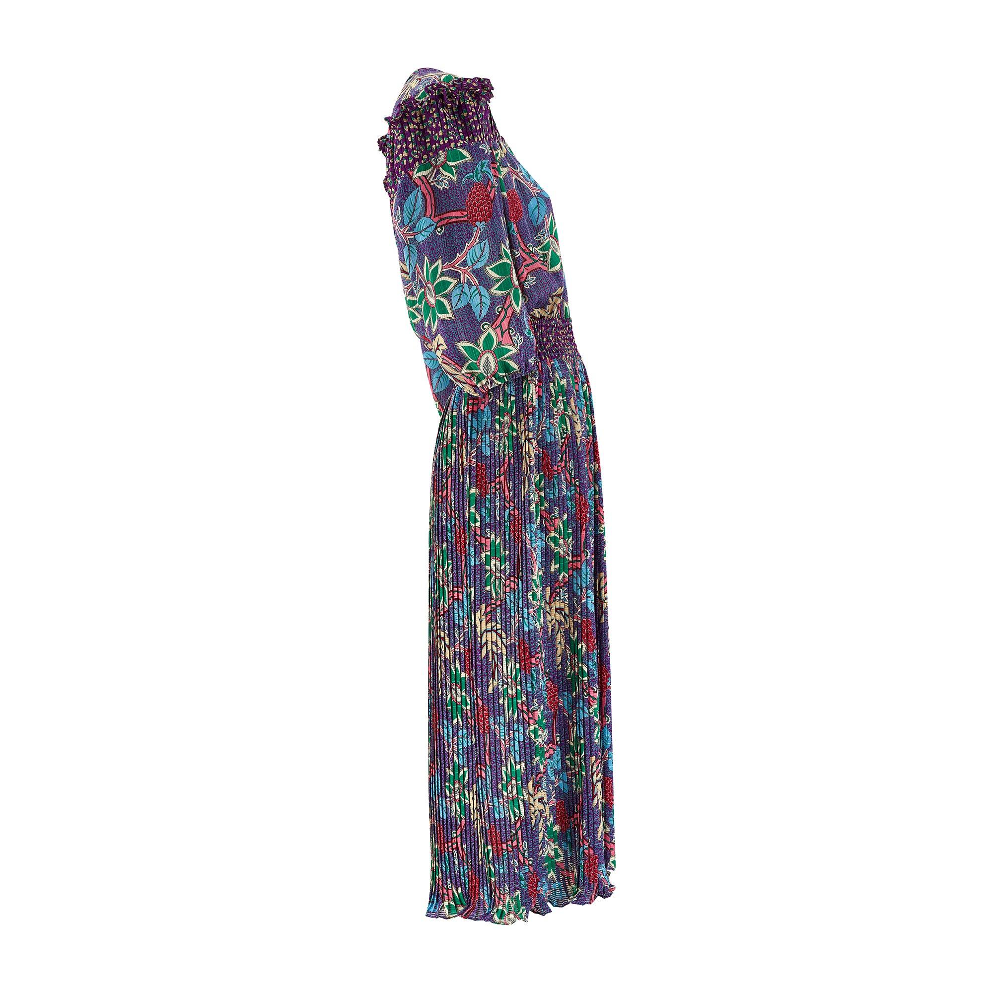 Fabriquée aux États-Unis, cette robe pleine de vivacité a été conçue par Susan Friar au début des années 1980. Appréciée pour ses imprimés excentriques de l'époque, cette robe met en valeur le violet, le vert, les fleurs esquissées et les minuscules