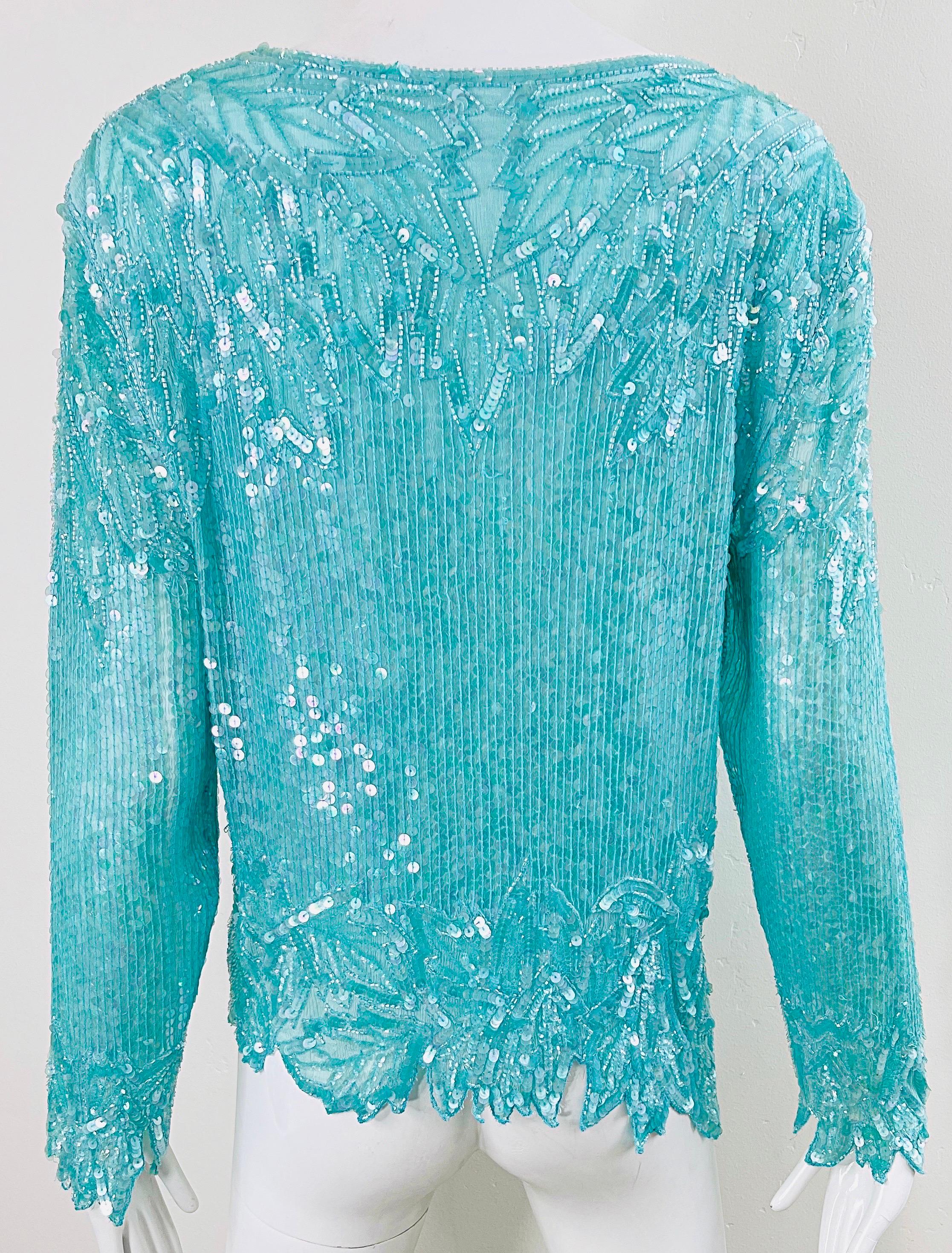 Beautiful late 80s SWEE LO turquoise blue silk chiffon sequin and beaded long sleeve top ! Features thousands of hand-sewn iridescent sequin and beads throughout the entire shirt. Asymmetrical scalloped hem and sleeves. Hook-and-eye closure at top