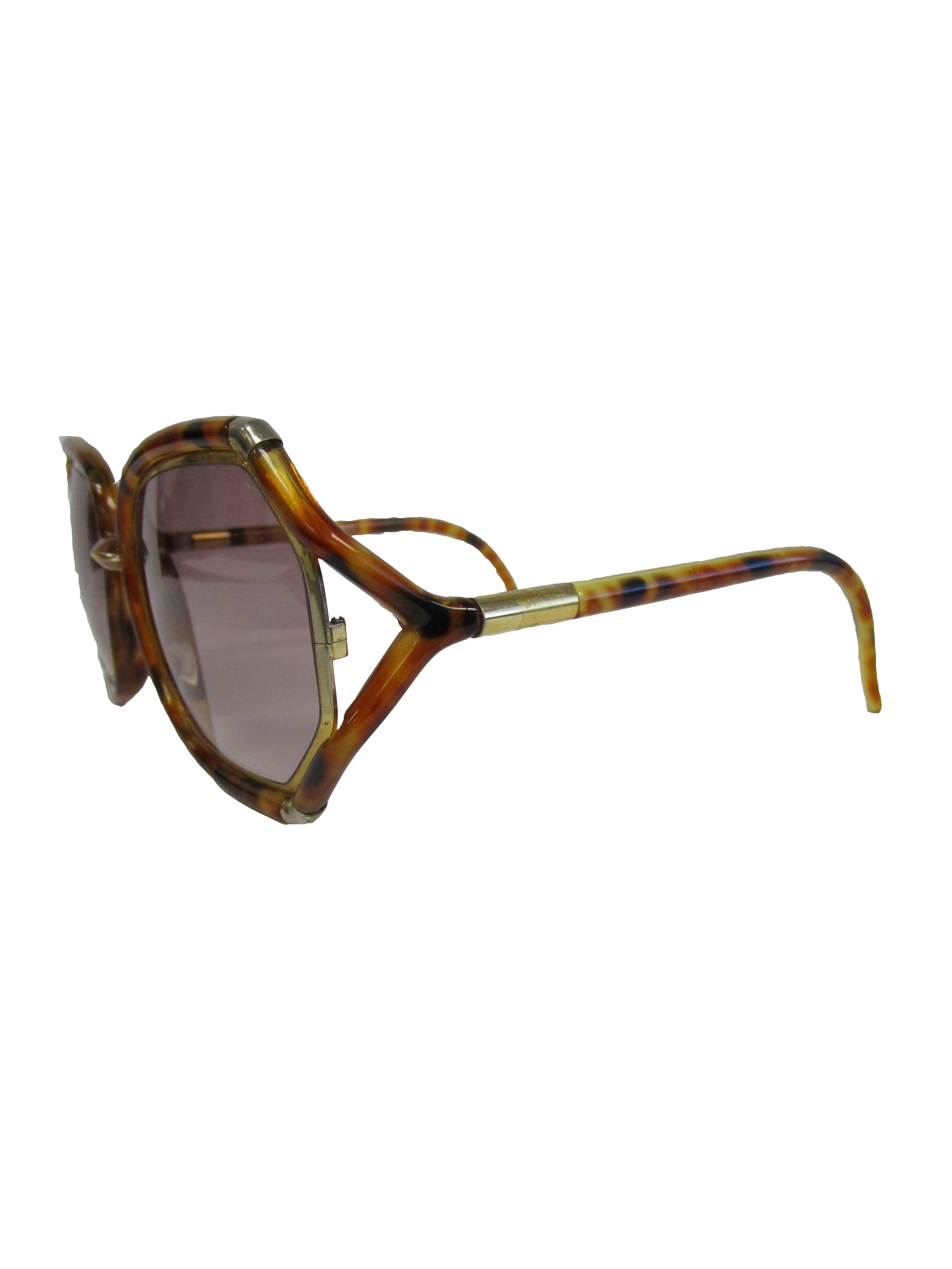 
Classic 1980's  Ted Lapidus sunglasses. These iconic shades feature an over-sized frame that connect to an interesting y-shaped arm, the lenses are a dusky tint and complement the sunglasses's earthy color! 
You can catch  stars such as Jennifer