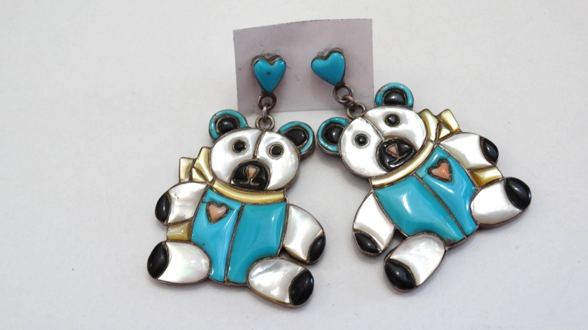 Rock a novelty earring with our adorable 1980s Zuni teddy bear earrings! Made of 100% silver. Heart shaped posts with Zuni turquoise inlayed, with pierced backings. Dangly teddy bear pendants with inlays of iridescent pearl, turquoise and black onyx