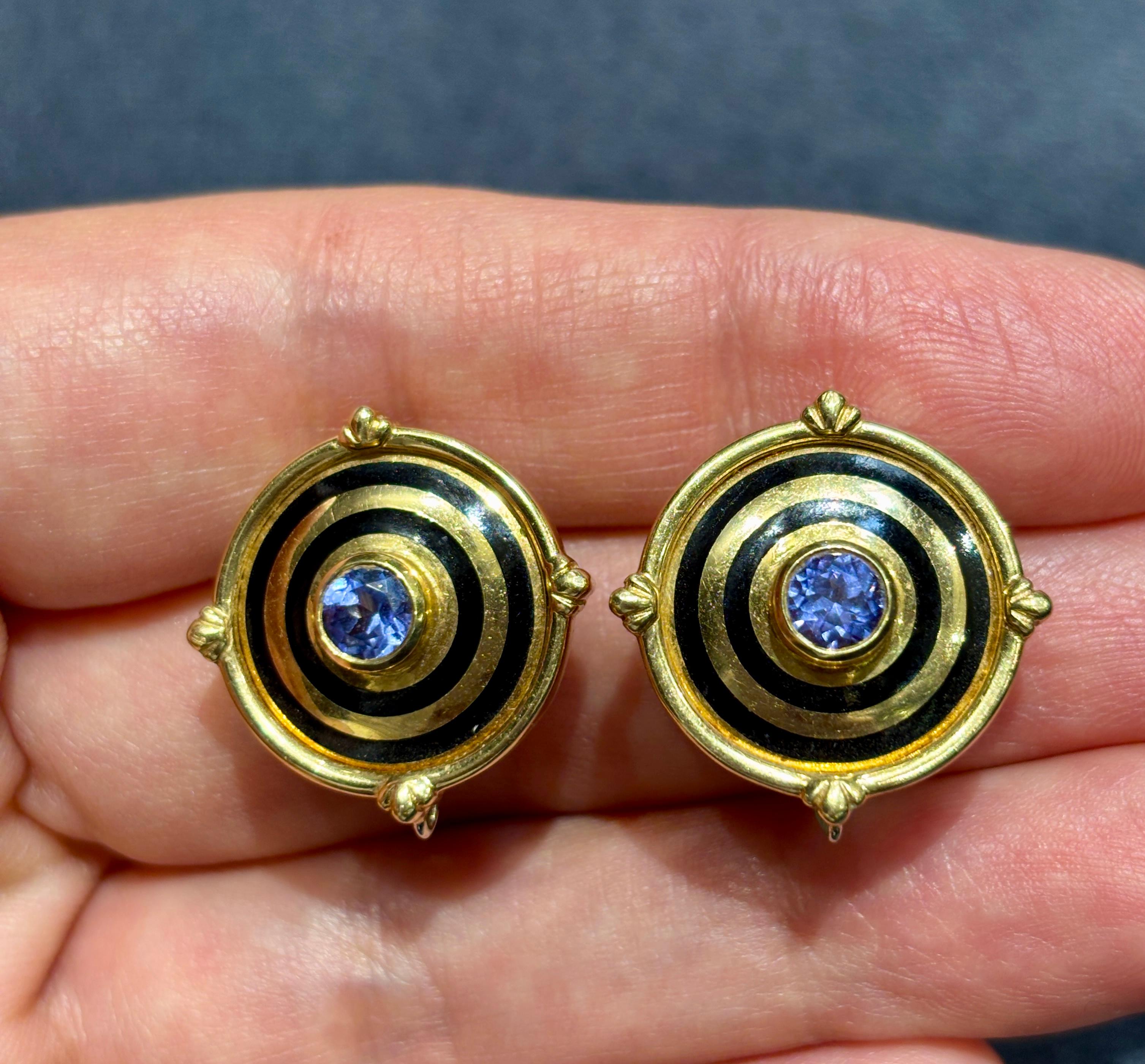 Questi eleganti orecchini a leva di Theo Fennell sono incentrati su tanzaniti a taglio rotondo. Il design circolare è accentuato dai cerchi di smalto che circondano le tanzaniti. Risalenti agli anni '80, gli orecchini sono comodi da indossare e sono