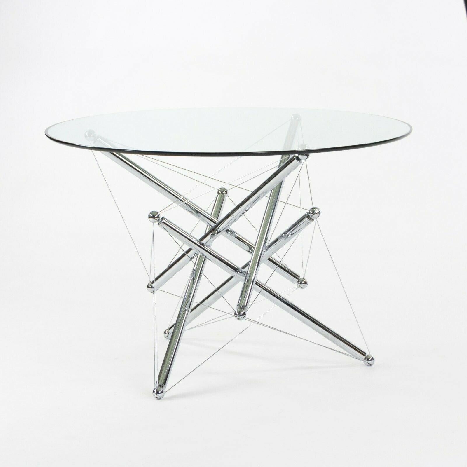 Listed for sale is a gorgeous and original 714 dining table, produced by Cassina. This table was designed by Theodore Waddell and was created after being inspired by Buckminster Fuller's tensile and tensegrity structures. The base uses cables to act
