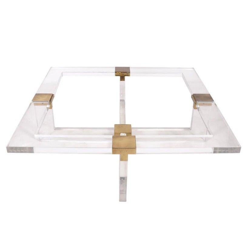 A vintage, late 20th century, Italian, 1970's thick acrylic and brass square coffee table by Sandro Petti. Mr. Petti was a well respected designer and architect who produced pieces for both Maison Jansen as well as L'Angolo Metallarte. This table
