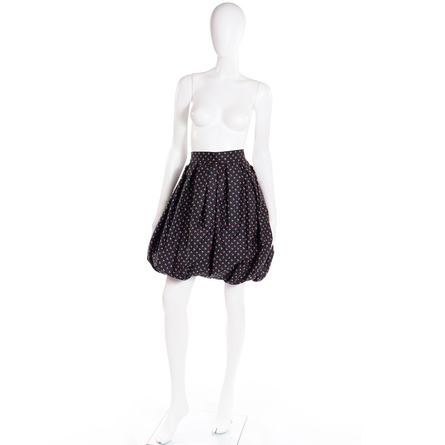 This is such a unique design for Thierry Mugler! This black cotton bubble skirt has tiny squares in shades of pink and cream. The skirt has a fixed waist with snaps and a hidden zipper and hook and eye for closure. Such a fun skirt to pair with a