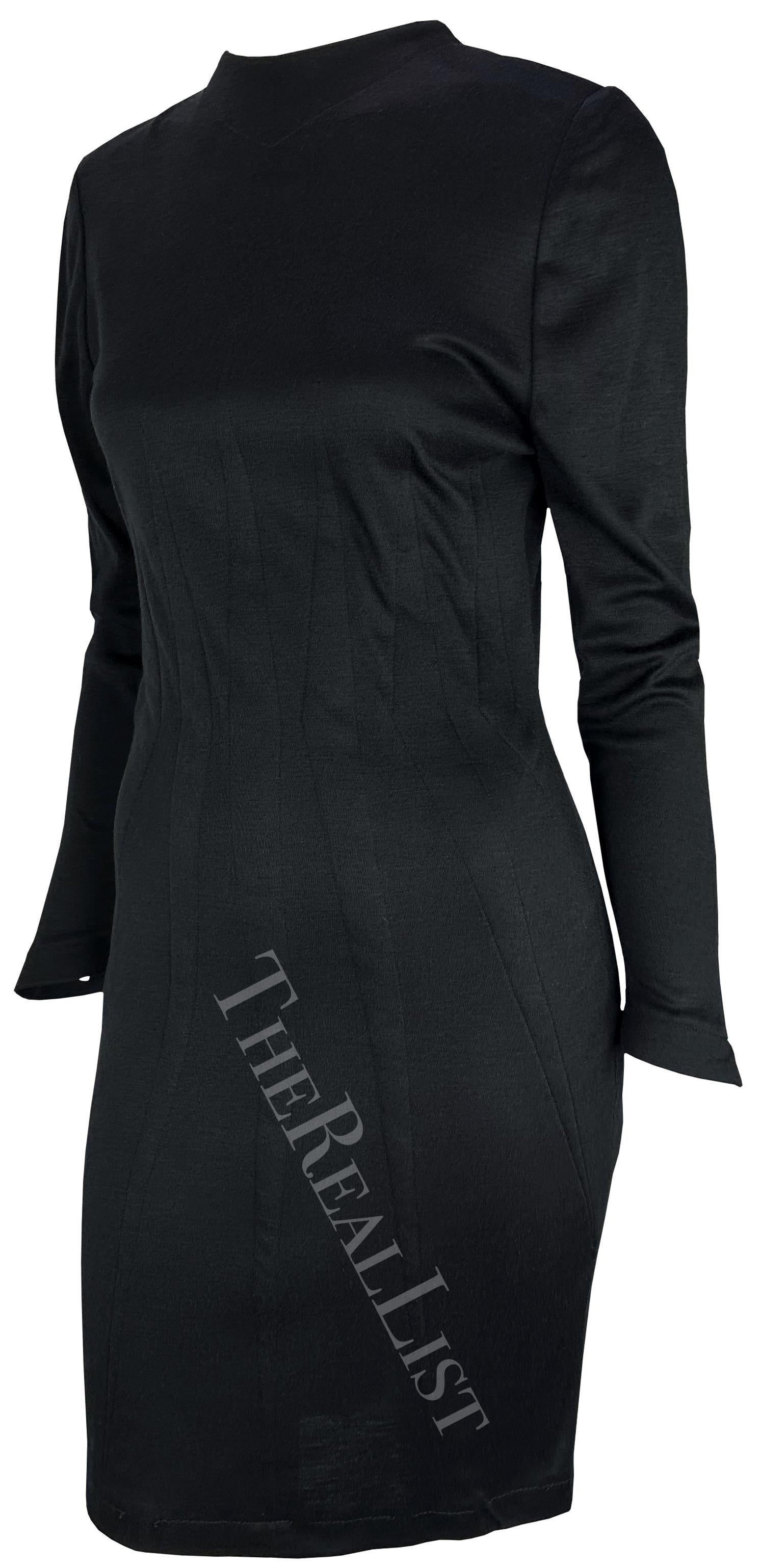 This 1980s Thierry Mugler dress features a sleek black design with a high neckline and structured darting throughout the bodice. The long sleeves and form-fitting silhouette add to the dress's elegant and minimalist style.

Approximate