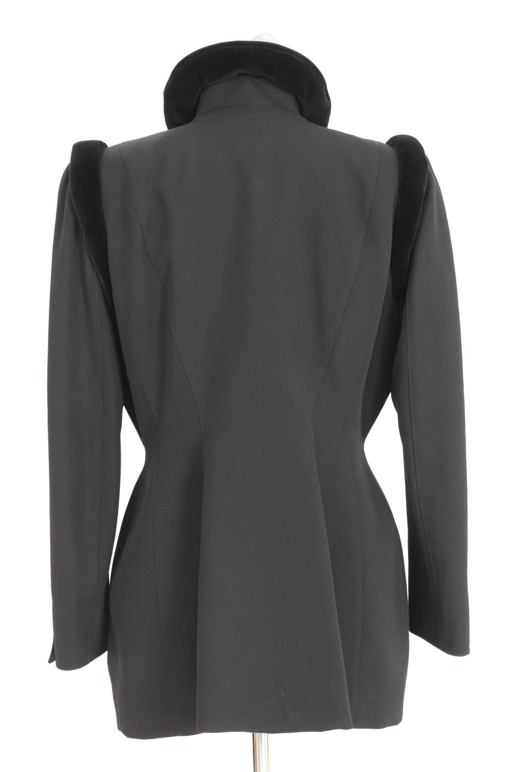 Thierry Mugler vintage women's 80s jacket. Double-breasted, black in 100% wool combed. Details in velvet. Elegant structured blazer. Space, futuristic design on the shoulders. Closure with clip buttons. Lined interior. Made in France. Excellent