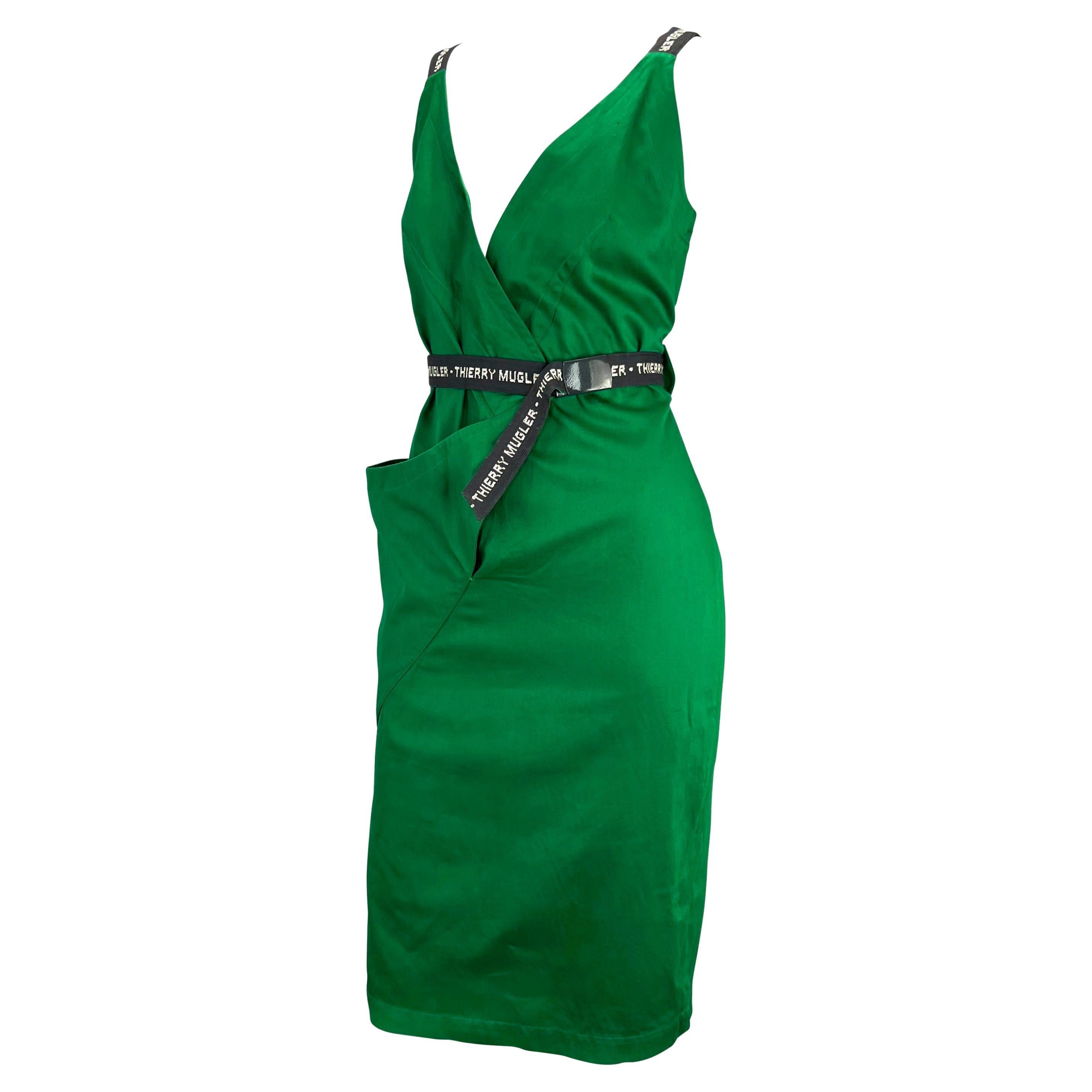 Presenting a vibrant green Thierry Mugler wrap dress, designed by Manfred Mugler. From the early 1980s, this cotton wrap dress features a v-neckline, one asymmetric pocket, and a grey built in belt. For the Mugler lover, this dress proudly boasts