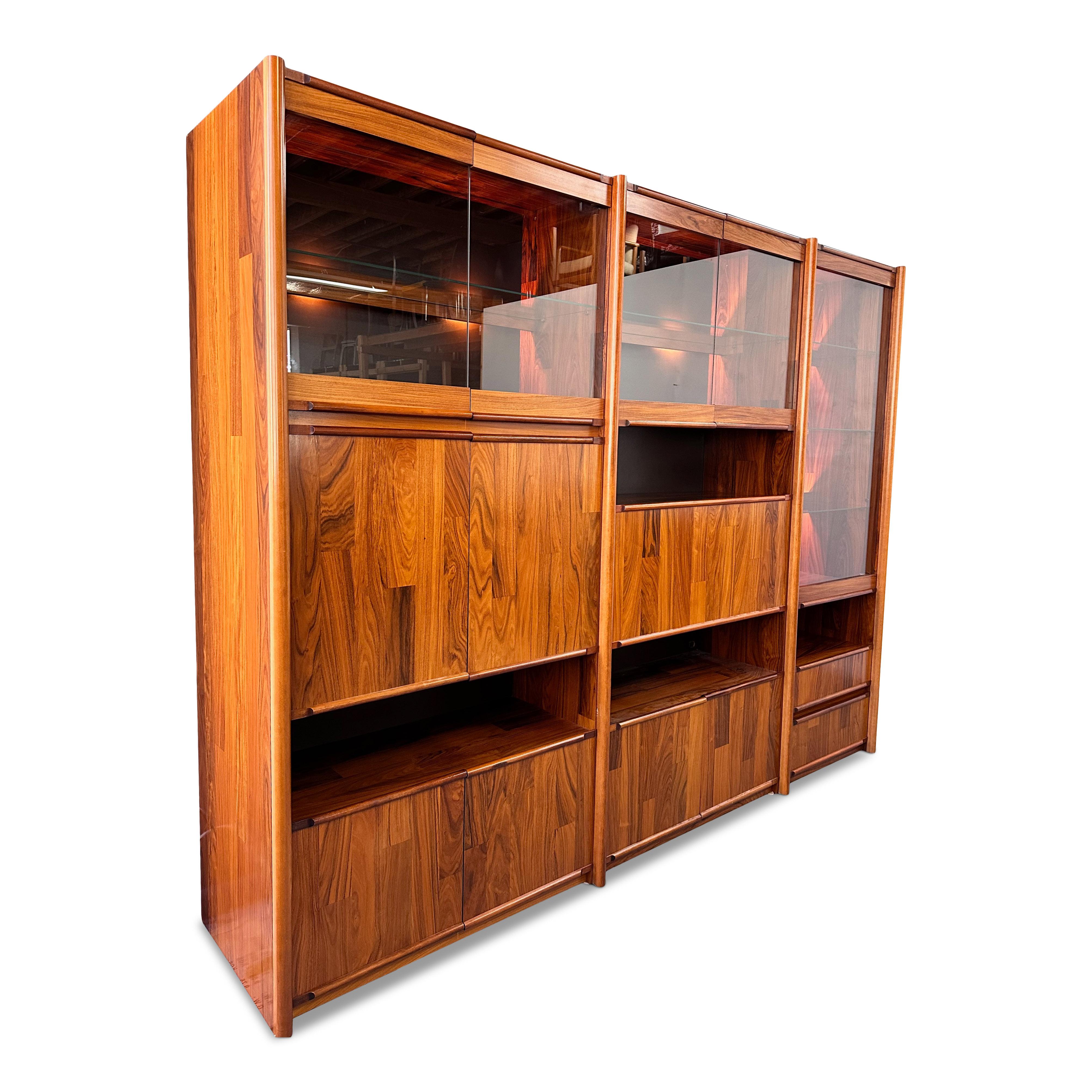 Really beautiful and interesting wall unit using rosewood veneer strips in the manner of celebrated Brazilian furniture designer Jorge Zalszupin. The shelves are also rosewood veneer and beautiful. The three units are lighted with calming low