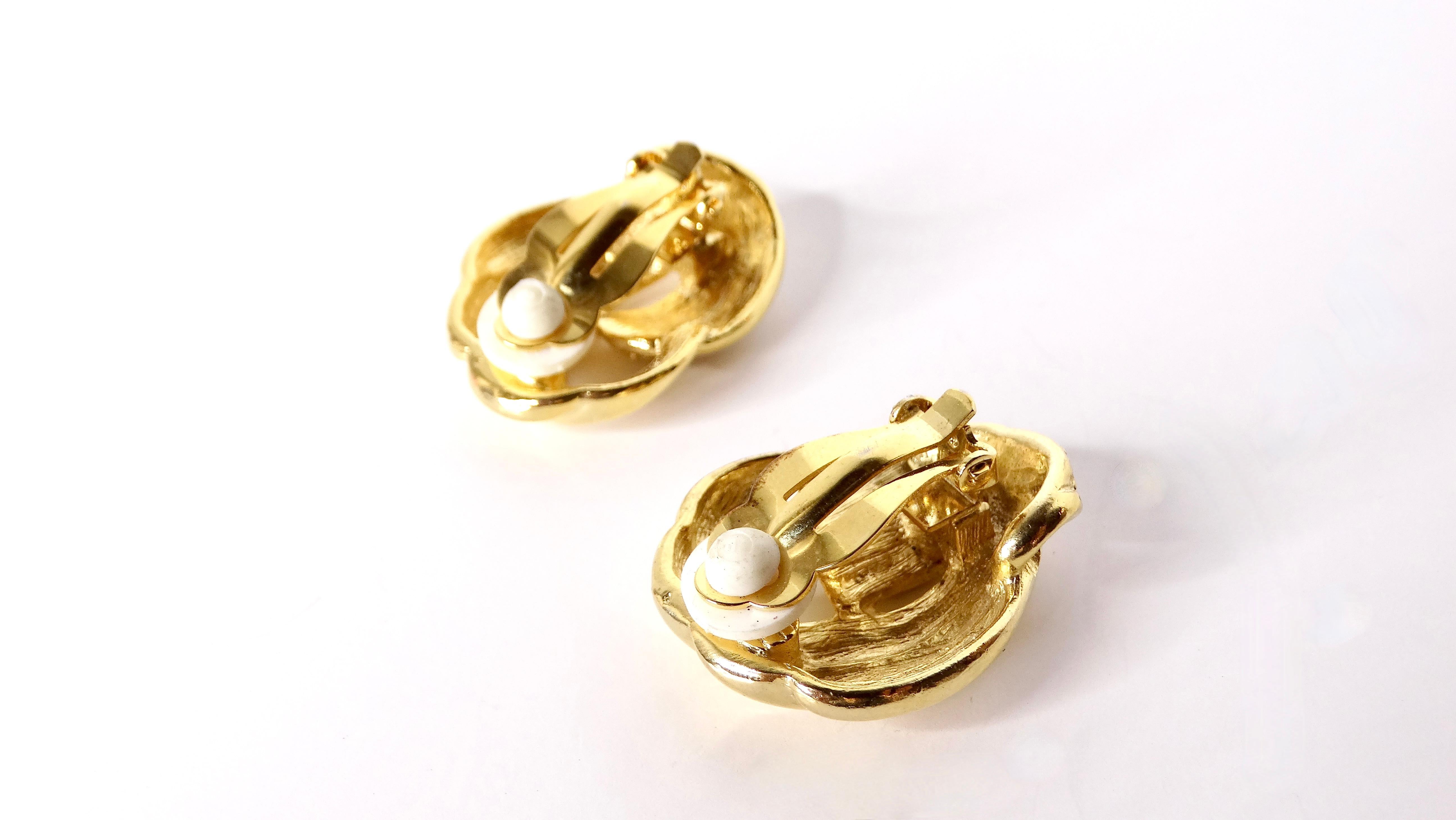 These stunning 1980s 18k gold-plated knot and crystal clip-on earrings are the epitome of vintage elegance and opulence. The intertwining knot design is beautifully accentuated with crystals that catch the light with every movement, making them