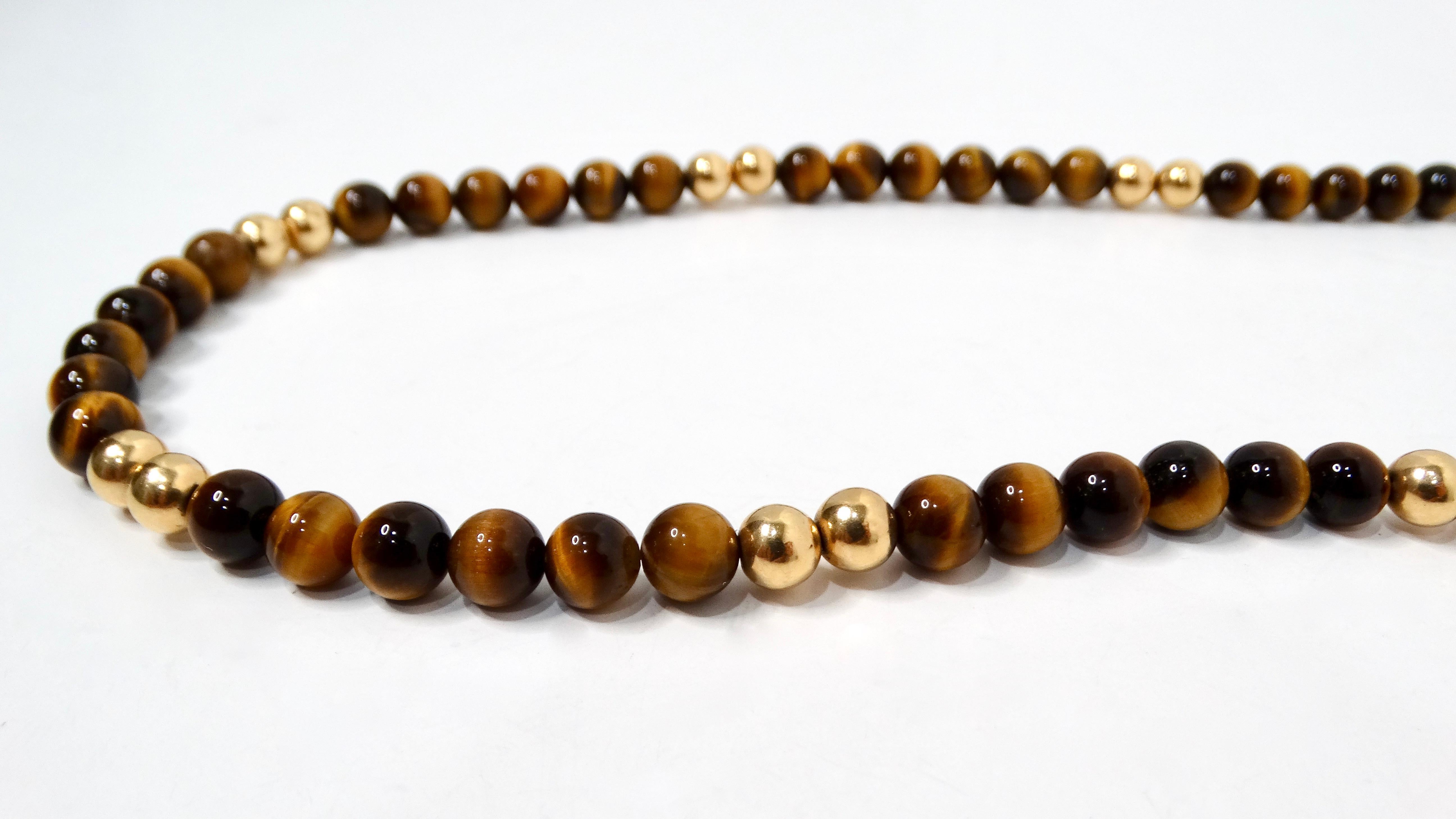 Questa splendida collana di perline in oro giallo 14k e occhio di tigre degli anni '80 è un pezzo unico che unisce l'eleganza vintage alla raffinatezza moderna. Realizzata con ricche e calde perle di occhio di tigre, rinomate per la loro