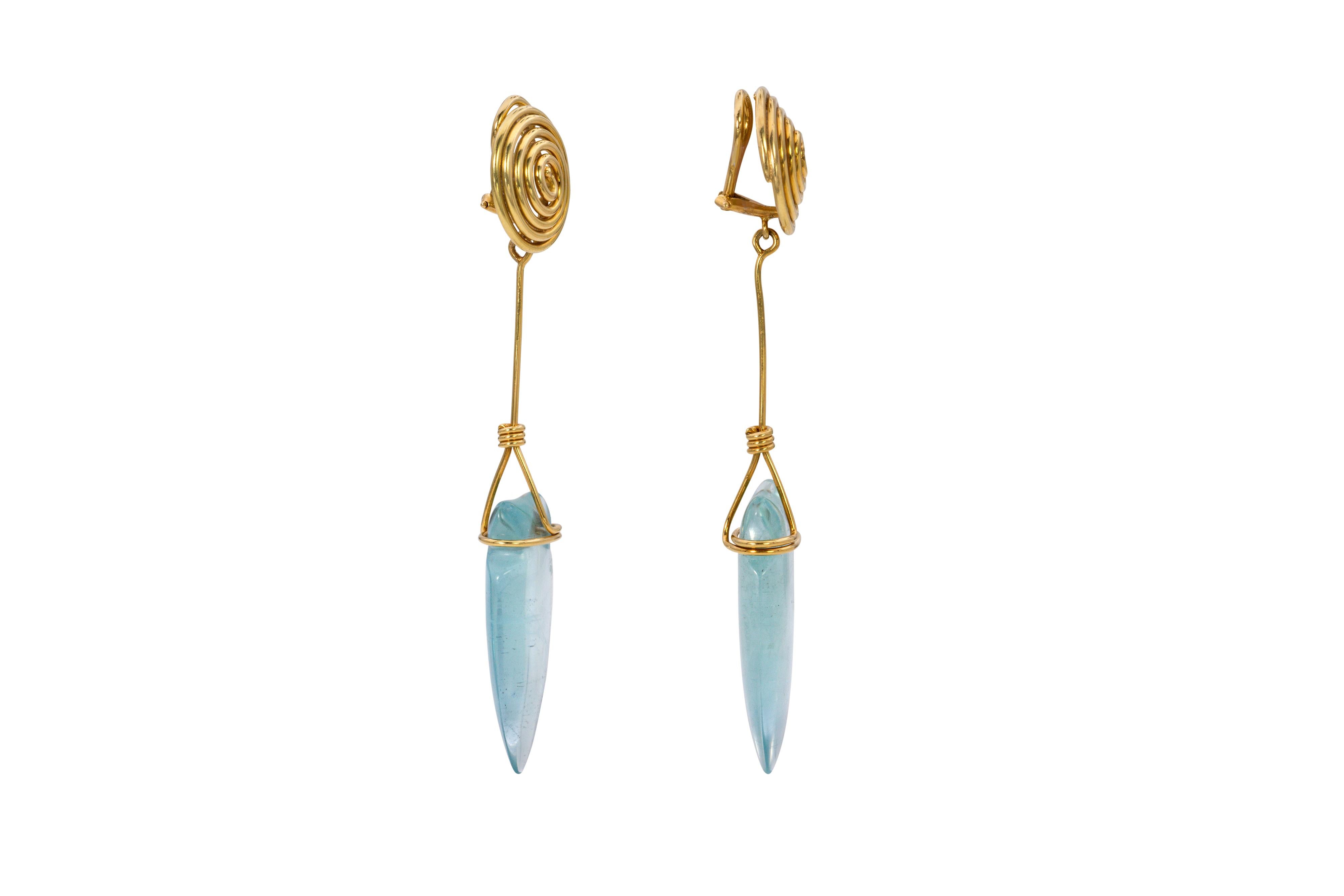 A pair of aquamarine and 18 karat gold dangle earrings, designed by fashion icon Tina Chow, 1980s. Earrings signed T. Chow, stamped 750, French import marks. Aquamarines signed © T. Chow. Clip-backs for non-pierced ears. 

These earrings represent