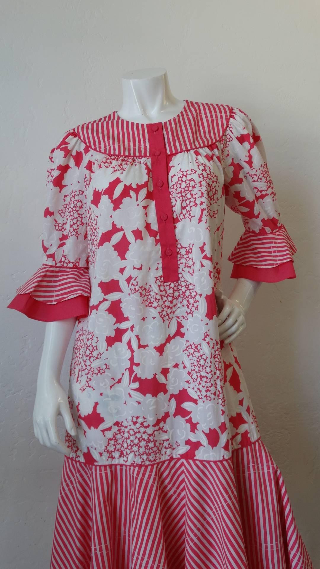 ¡El vestido ochentero más adorable de la diseñadora de Honolulu Tori Richard! Confeccionada con un tejido de algodón estampado de flores rosas y blancas, contrastado con rayas a lo largo de las mangas, la falda y el canesú. Mangas cortas de campana
