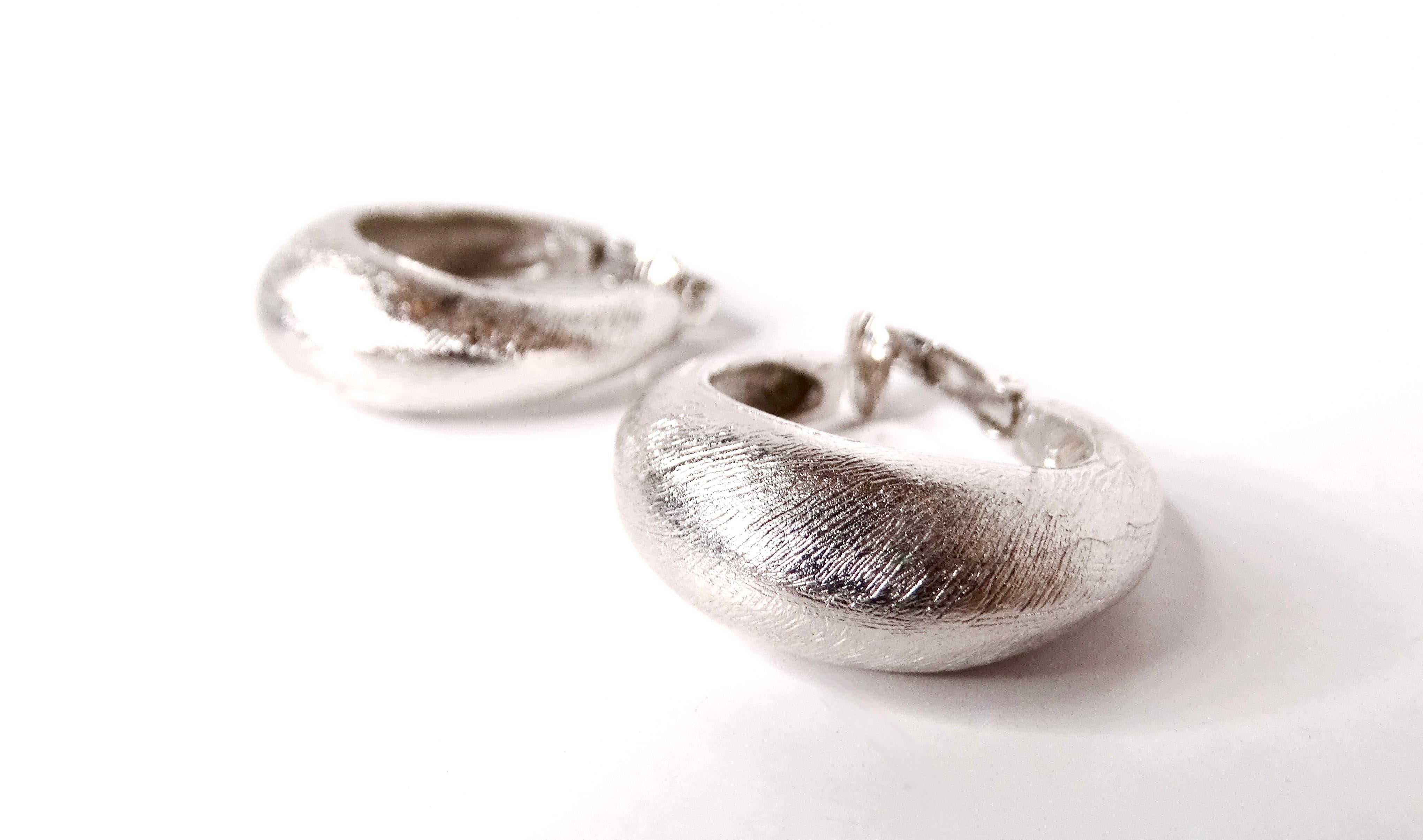 Step back in time with these exquisite Circa 1980s Trifari Sterling Silver Textured Clip-On Hoop Earrings, a testament to vintage elegance and craftsmanship. These etched hoop earrings feature a stunning textured finish that captures the essence of