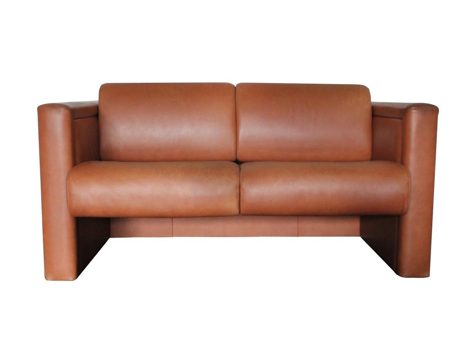 This iconic modern-design of peerless quality is a 2-seat lounge seating sofa designed by Trix and Robert Haussmann and manufactured by the world-renown Furniture House, Knoll International. Generously upholstered back and seat cushioning in a tan