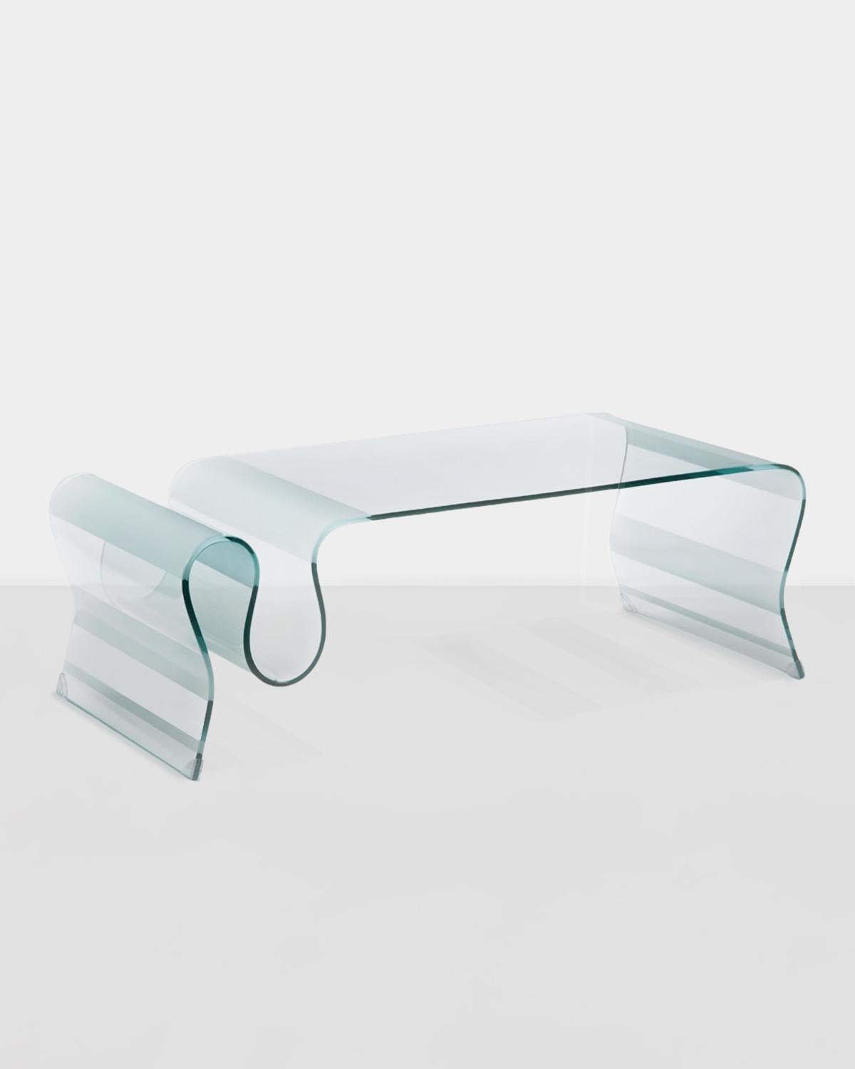1980s Undulating Glass Coffee Table boasting subtle frosted accents. The wave portion of the table provides a classy and functional touch, creating the perfect storage space to house magazines, books and other accessories. A truly timeless and