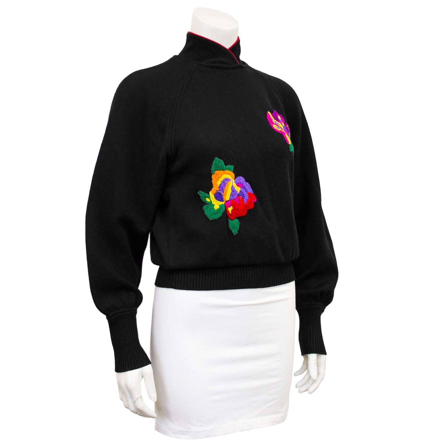 1980s Ungaro knit mandarin collar sweater. Black with red trim at the neck and bright multicolour embroidered flowers. Ribbed neckline, cuffs and waist band. Three small black button closures at nape of neck with small keyhole. Slight blouson fit.