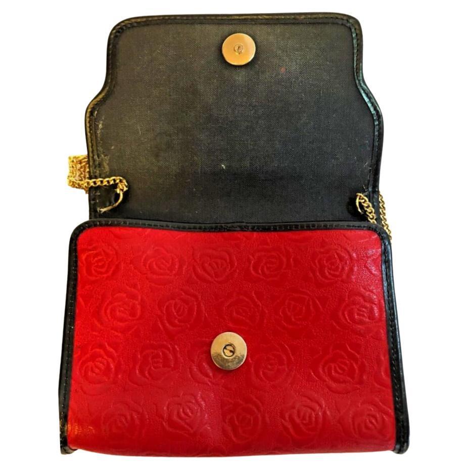 L'opulence parisienne se retrouve dans ce sac à bandoulière Ungaro Paris Red Embossed des années 1980 avec chaîne en or. Le somptueux cuir rouge embossé, rehaussé de détails noirs élégants, rayonne de sophistication et de raffinement. Orné d'une