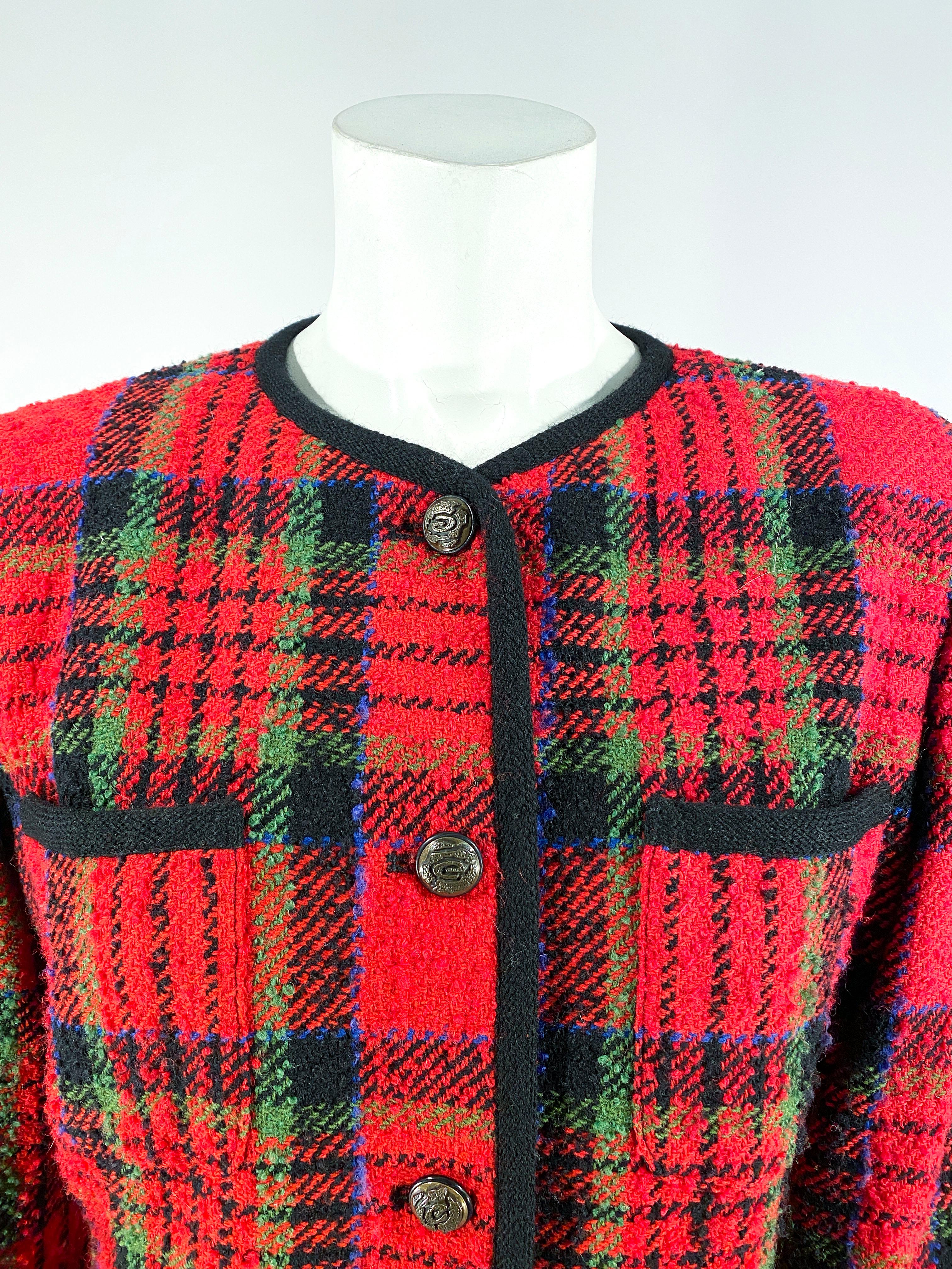 1980s Ungaro wool blend plaid blazer featuring green blue and black stripes on a red background. The face has four pockets all edges with thick black piping that matches the neckline and hem of the sleeves. The shoulders are padded for a top-heavy