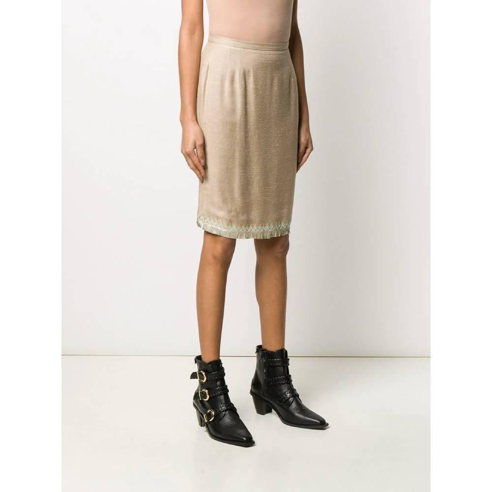 Valentino short straight skirt in beige silk blend with decorative leather details. Model with high waist, zip and button closure. Length above the knee. Lined.
Year: 80s

Made in Italy

Size: XS

Flat measurements

Height: 56 cm
Waist: 33 cm
