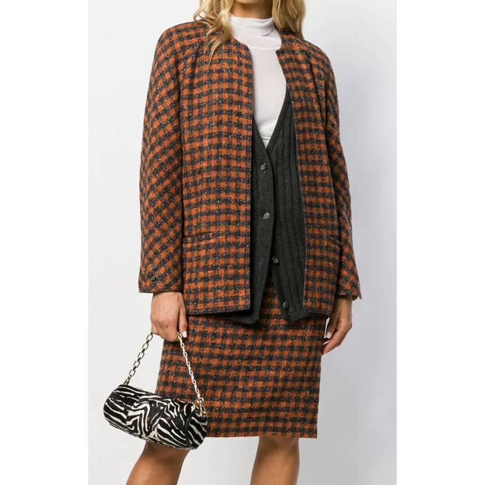 Valentino suit with black and brown checked pattern, round neck jacket with black knitted insert and buttons, welt pockets, long sleeves and cuffs with buttons, straight knee-length skirt and back slit with buttons.

Years: 80s

Made in Italy

Size: