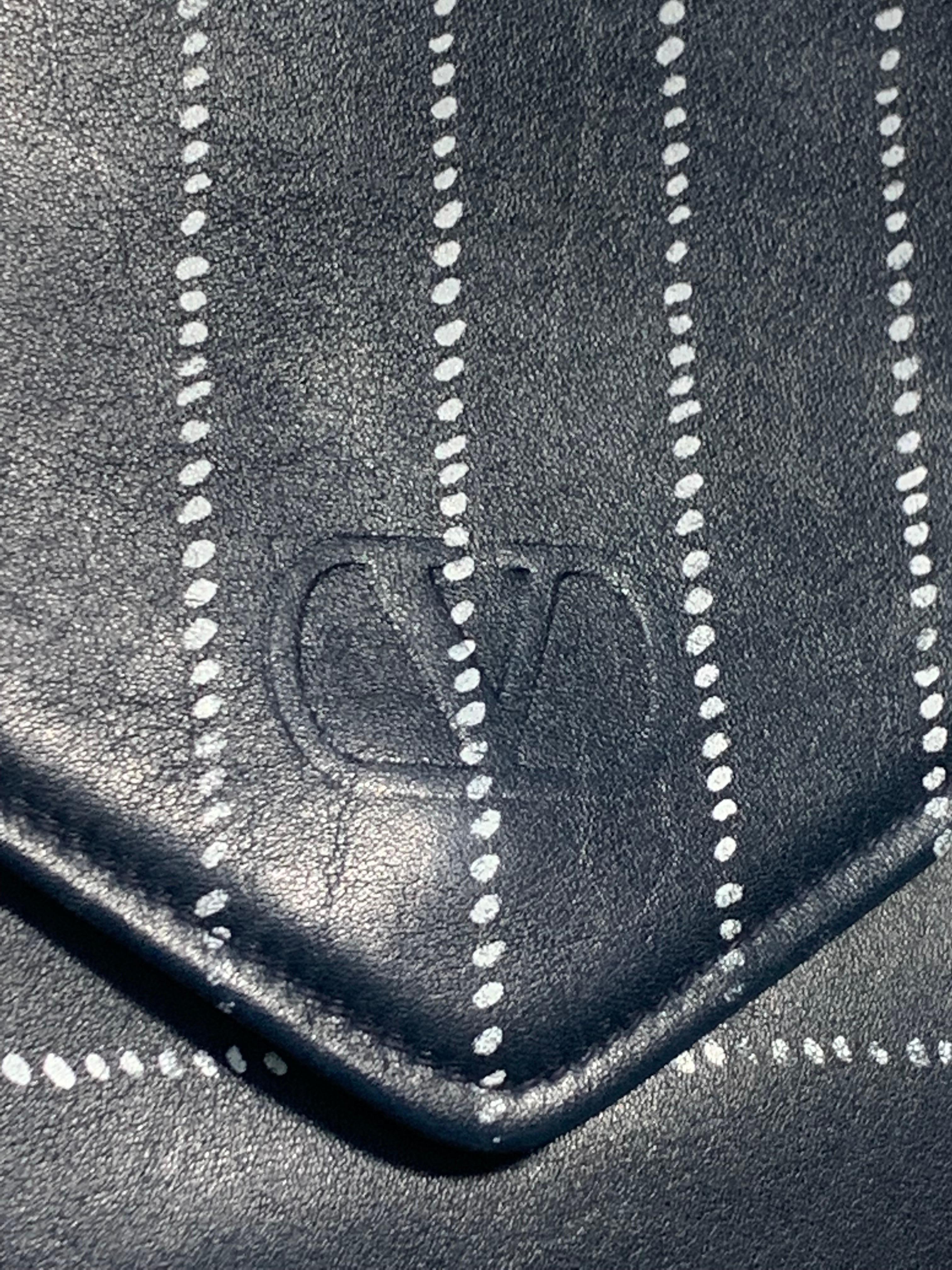 Pochette convertible en forme d'enveloppe en cuir d'agneau marine Valentino des années 1980, avec détails à rayures. 
La bandoulière croisée en chaîne peut être rentrée pour servir de pochette. Taille moyenne très utilisable pour accueillir un