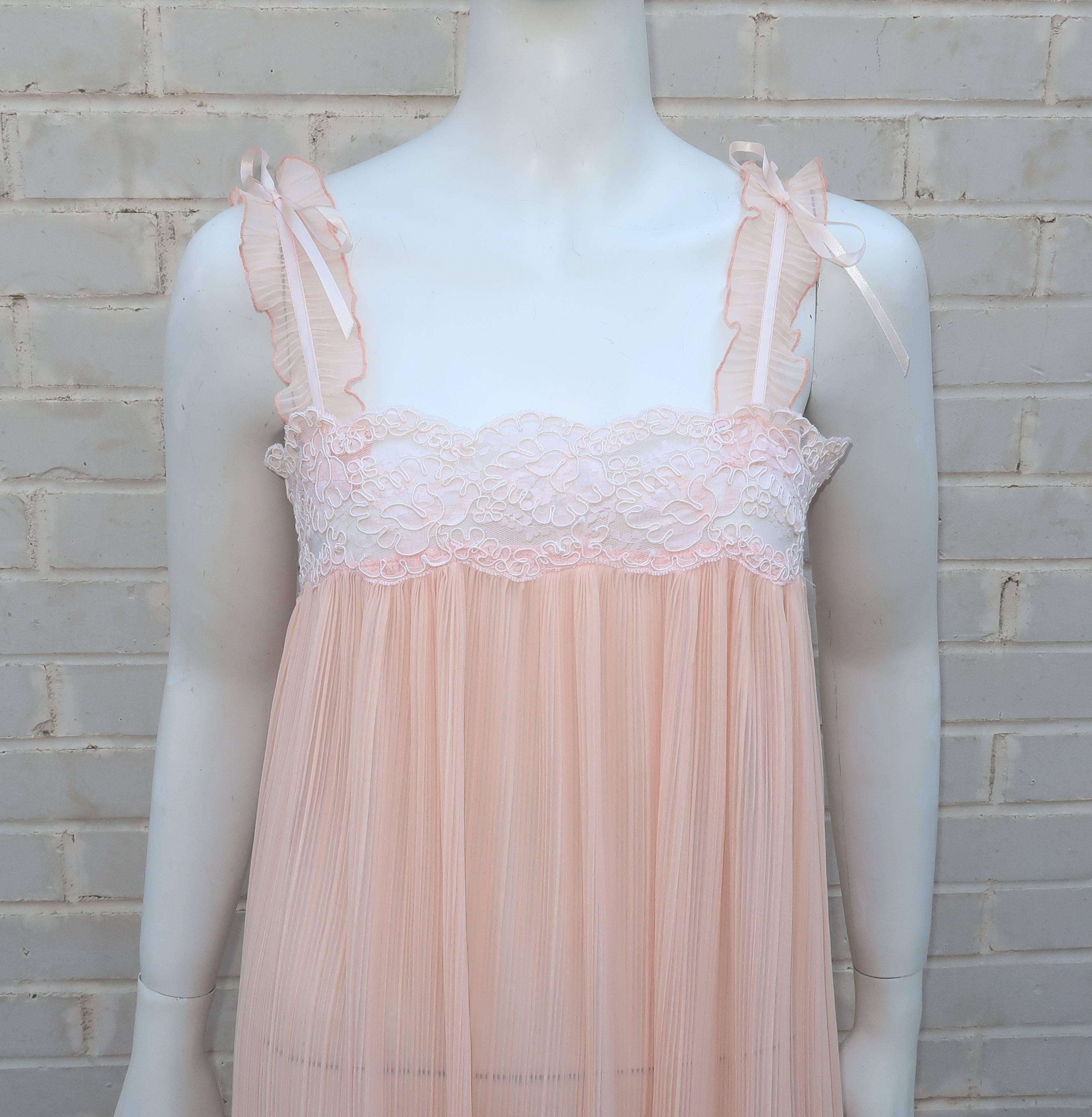 This 1980's Valentino negligee is an ethereal confection of pale peach micro pleated silk with an intricate lace bodice and satin ribbon details.  The gauzy sheer look is the ultimate in femininity with high slits at the sides and ties for modesty. 