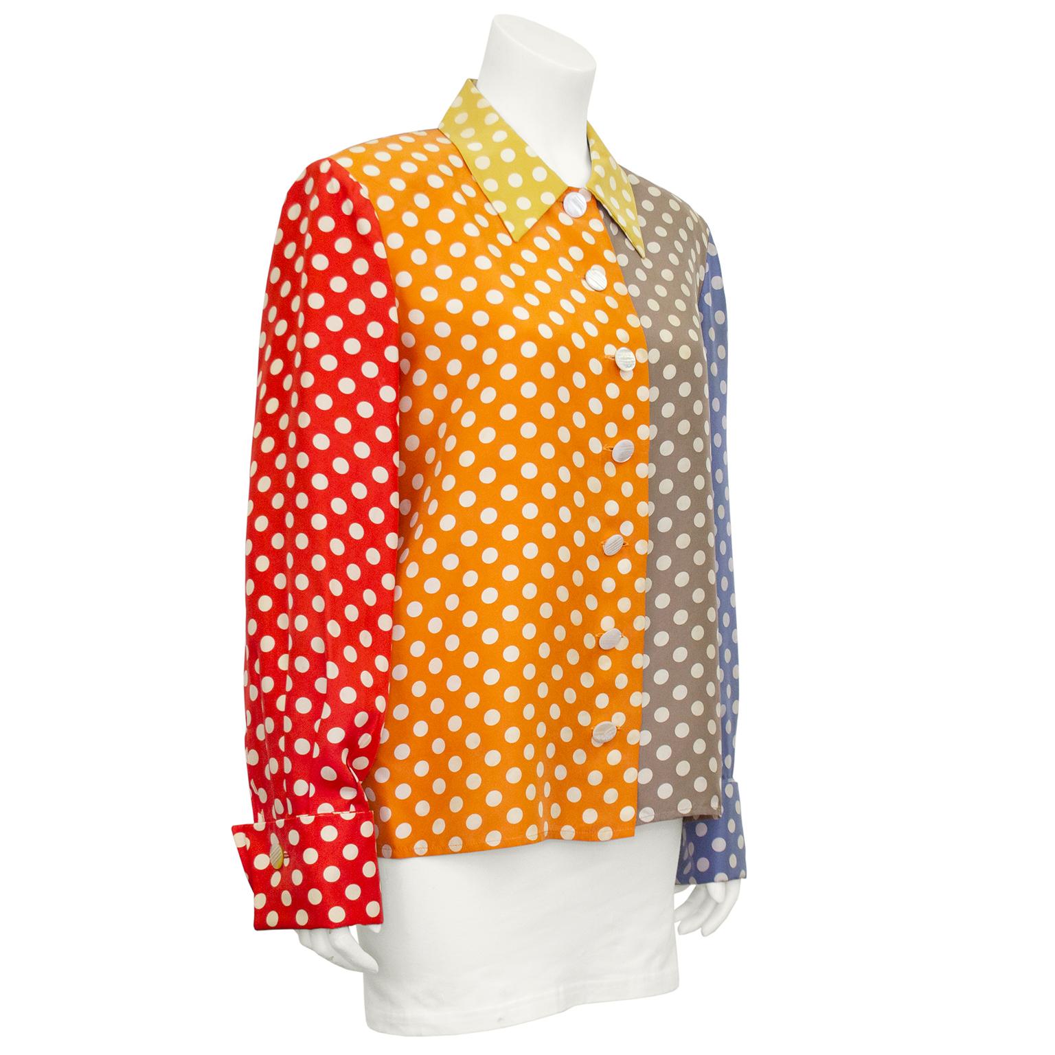 Simpatica e divertente camicia di seta Valentino degli anni '80. Blocchi di colore: colletto giallo, arancione e grigio per tutto il corpo con una manica rossa e una blu chiaro. Tutti i pois bianchi. Bottoni rotondi in madreperla bianca che imitano