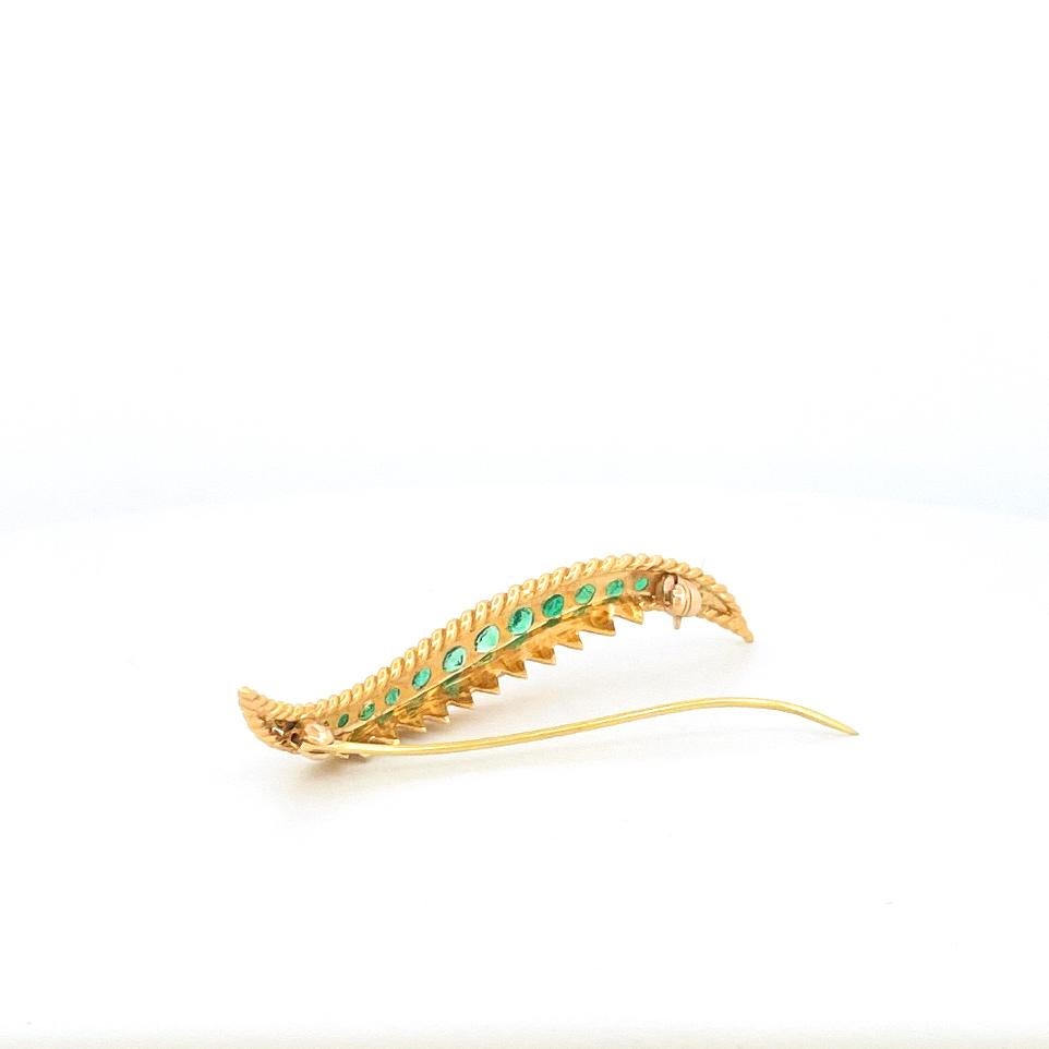 From the designer Van Cleef & Arples is an 18 karat yellow gold brooch crafted in the 1980’s. This piece is designed with a single line of graduate round cut emeralds with an approximate combined weight of 1.0 carat. This brooch has a round hinge