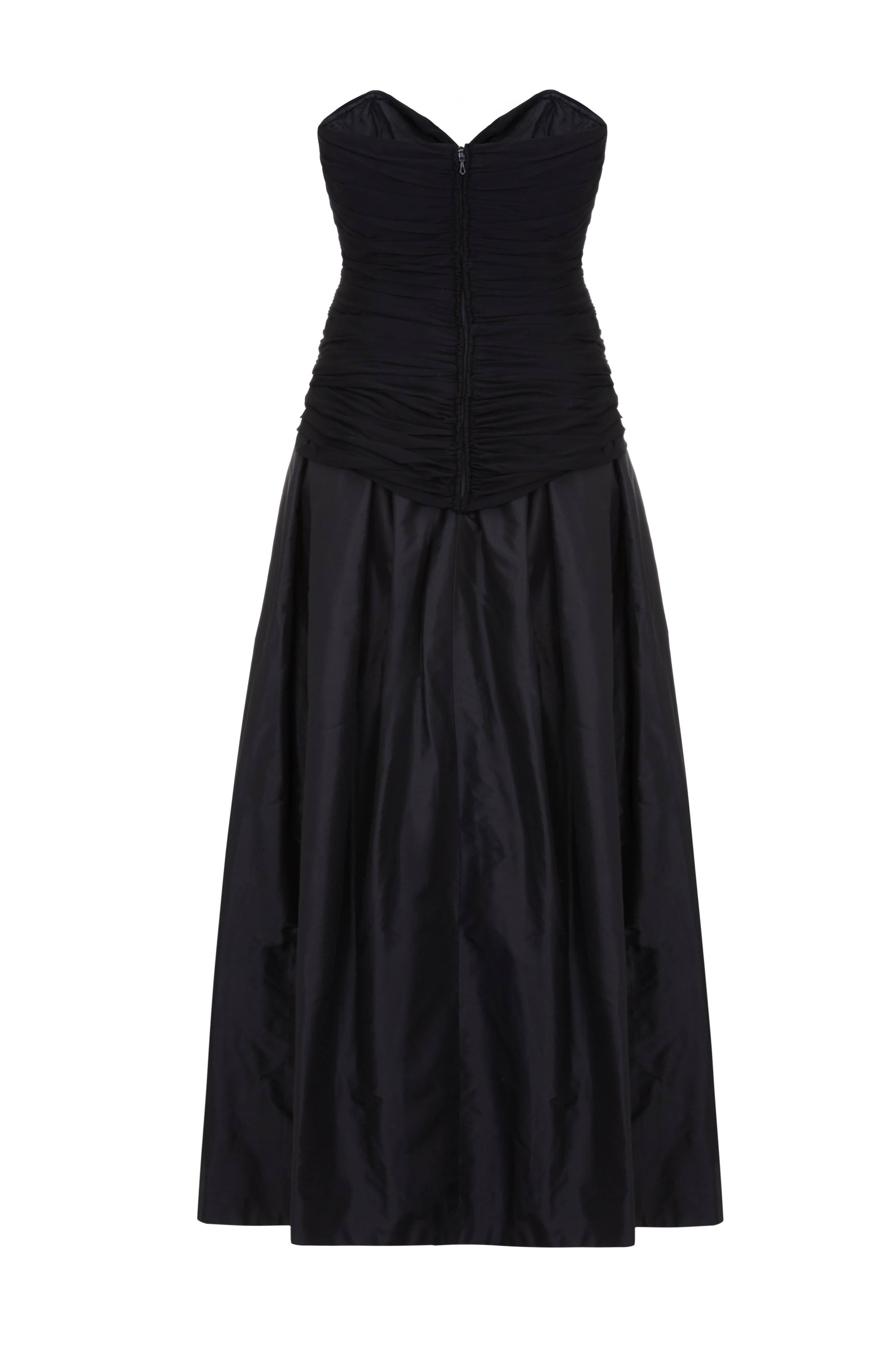 This elegant black couture evening gown by Vicky Tiel with gathered silk jersey bodice and silk taffeta skirt is of exceptional quality and has beautiful construction. This lovely strapless dress has a seductive sweetheart neckline which plunges