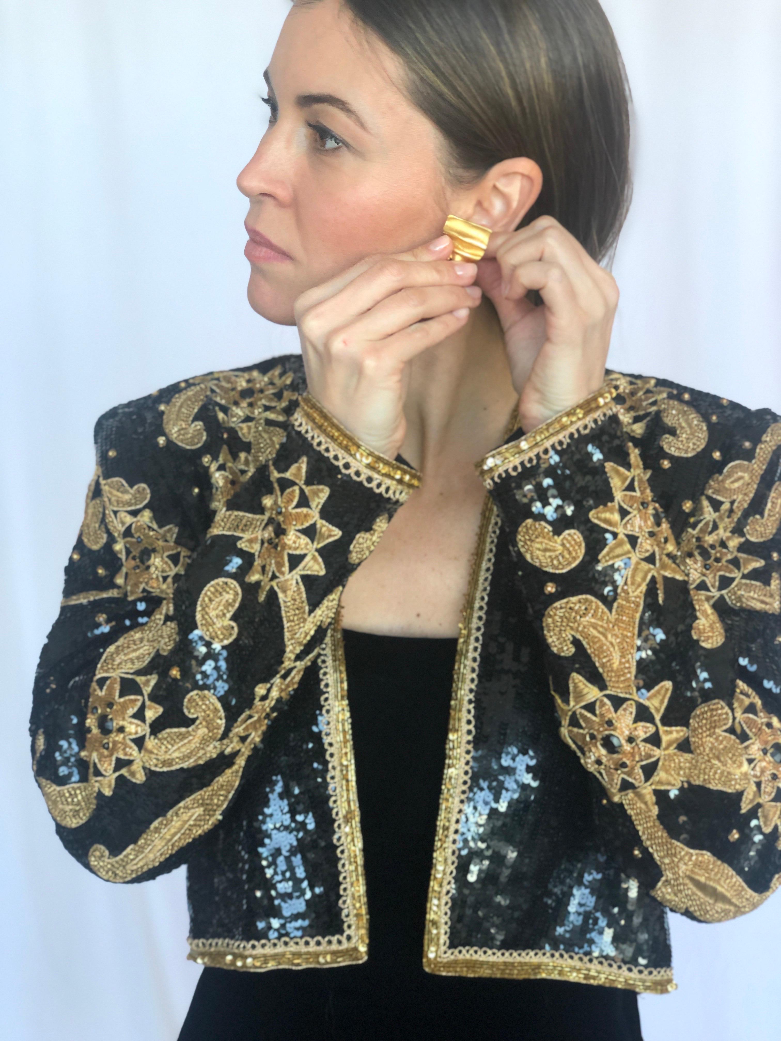 1990s Victor Costa incredible couture level bolero fully covered in black sequins and an intricate gold embroidered design. The gold pieces look like rope. A gold line of beads and rope line the cuffs, hem and collar and the rest of the beading is a