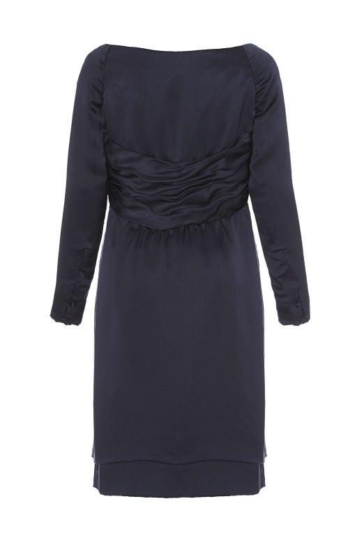 This stylish and elegant late 1980s to early 1990s navy silk evening dress was designed by British couture designer Victor Edelstein. Edelstein founded his own British couture fashion house in the late 1970s after designing for Christian Dior.