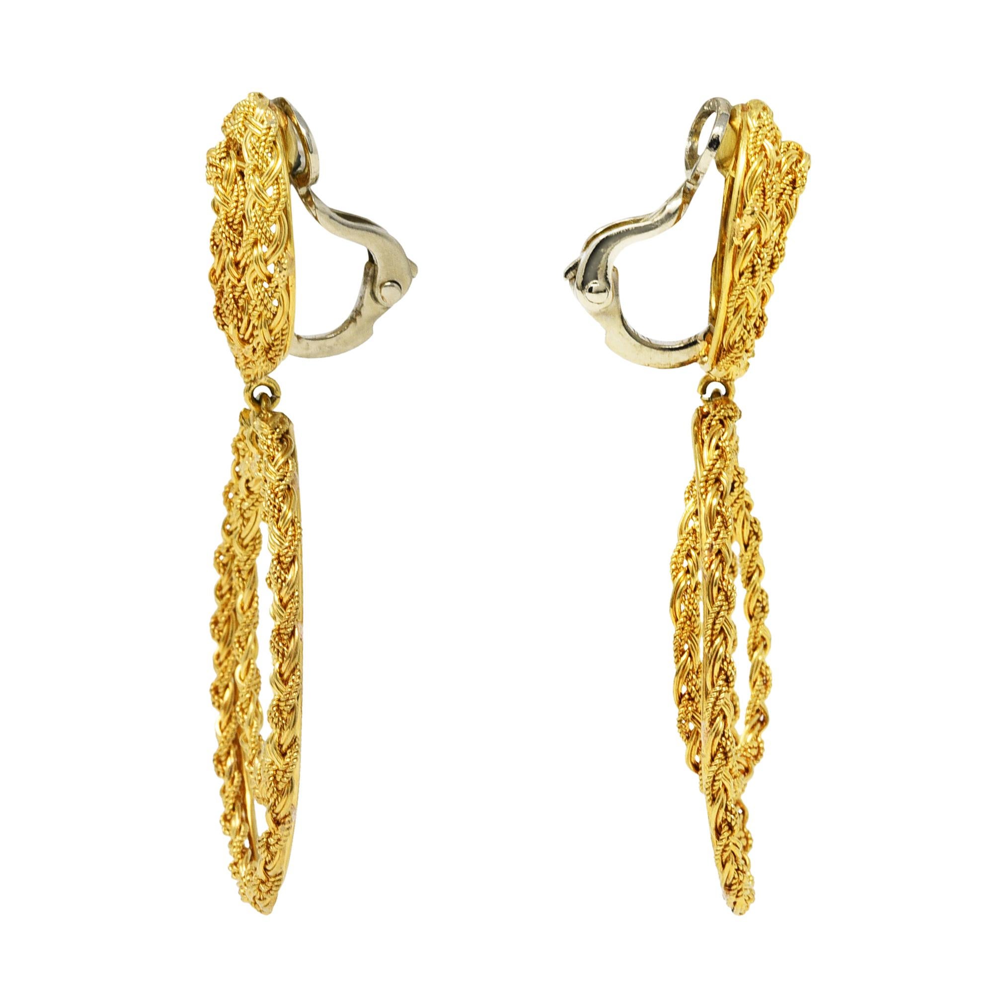 Doorknocker style earrings with a double loop oval surmount

Suspending a larger more articulated double loop drop

Entirely comprised of texturous and braided gold

Completed by white gold hinged backs

Stamped 18 for 18 karat gold

Circa: