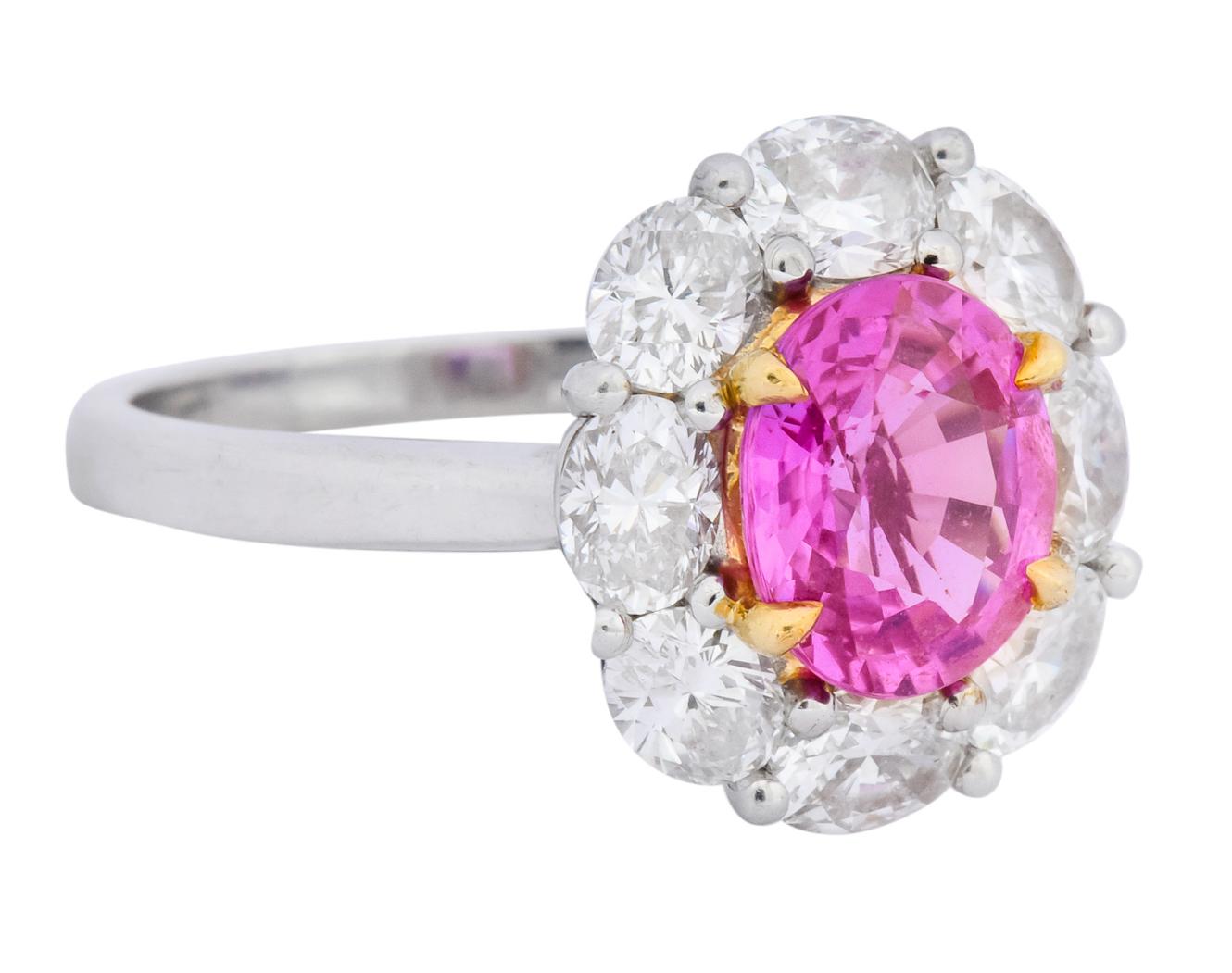 Centering an oval cut pink sapphire, claw set in 18 karat yellow gold, weighing approximately 2.25 carats

Sapphire is a transparent, saturated pink with hints of violet

With a surround of oval cut diamonds weighing approximately 2.00 carat total,